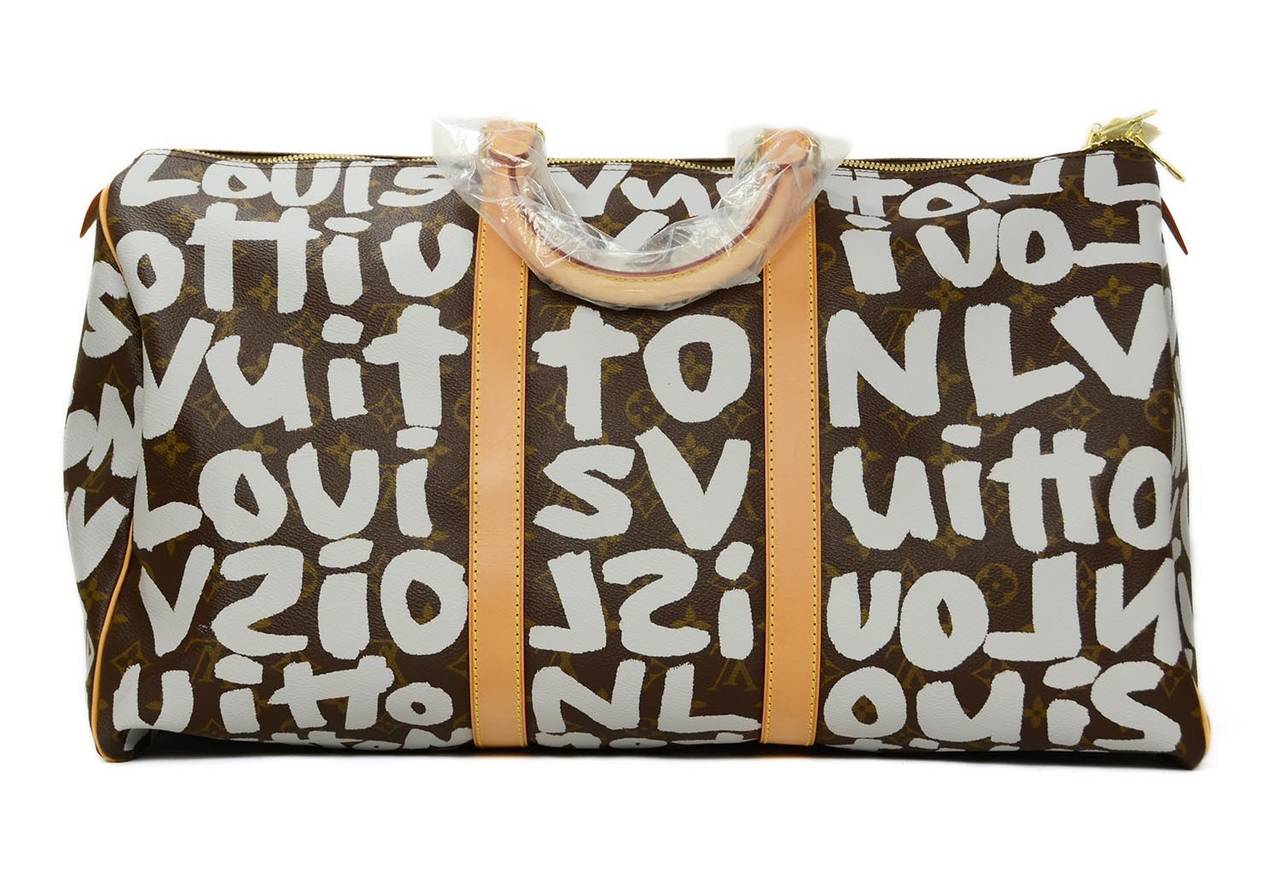 Louis Vuitton Steven Sprouse 50cm Graffiti Keepall Bag
Features original graffiti print by artist Steven Sprouse
Made in: France
Year of Production: 2001 
Color: Brown monogram with grey/silver graffiti written all over bag 
Materials: Canvas