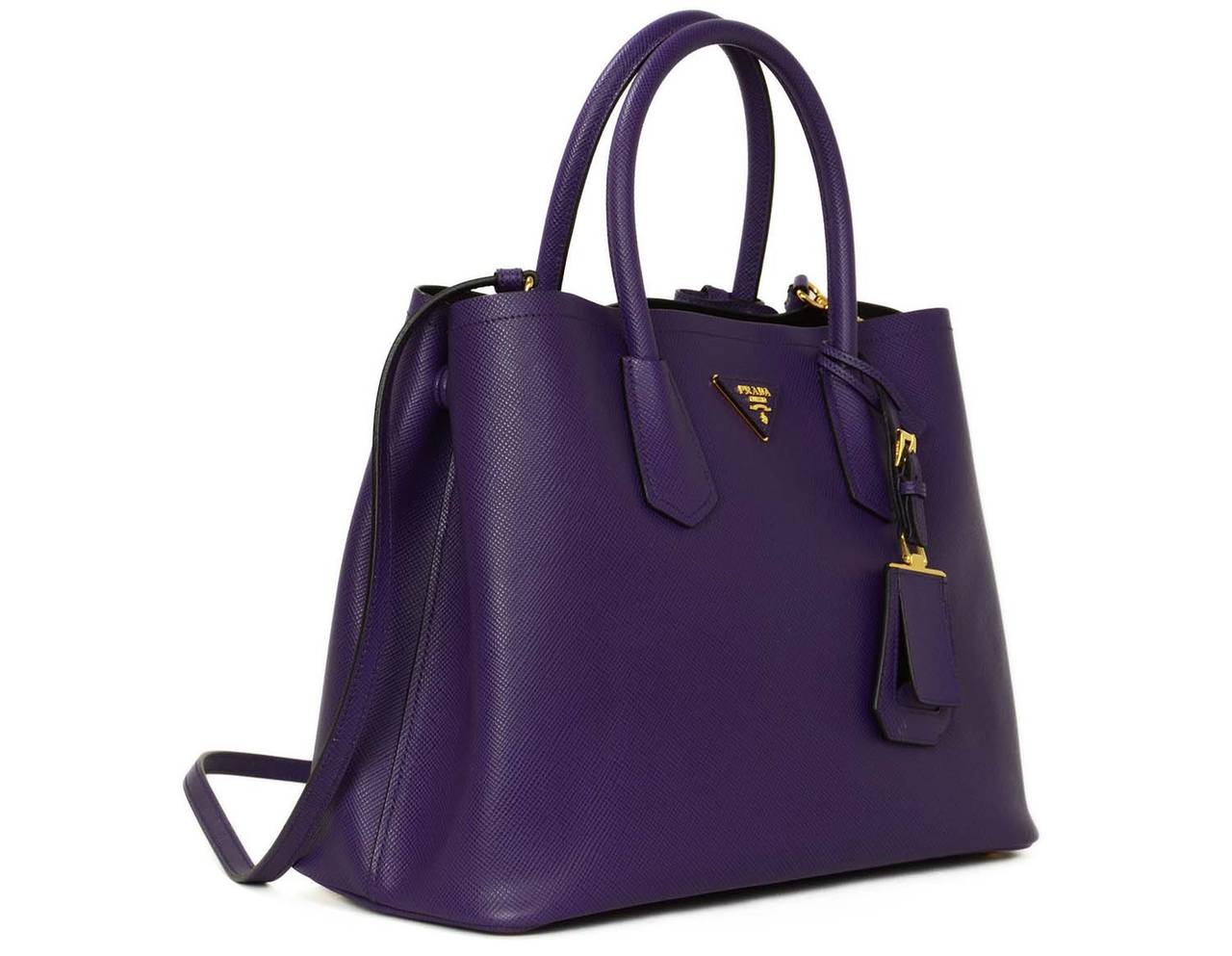 This bag can be worn hand held or can be worn on the shoulder or crossbody using the adjustable strap. Also features a removable tag on the front of the bag.

-Made in: Italy
-Year of Production: 2014
-Color: Viola purple
-Materials: Saffiano