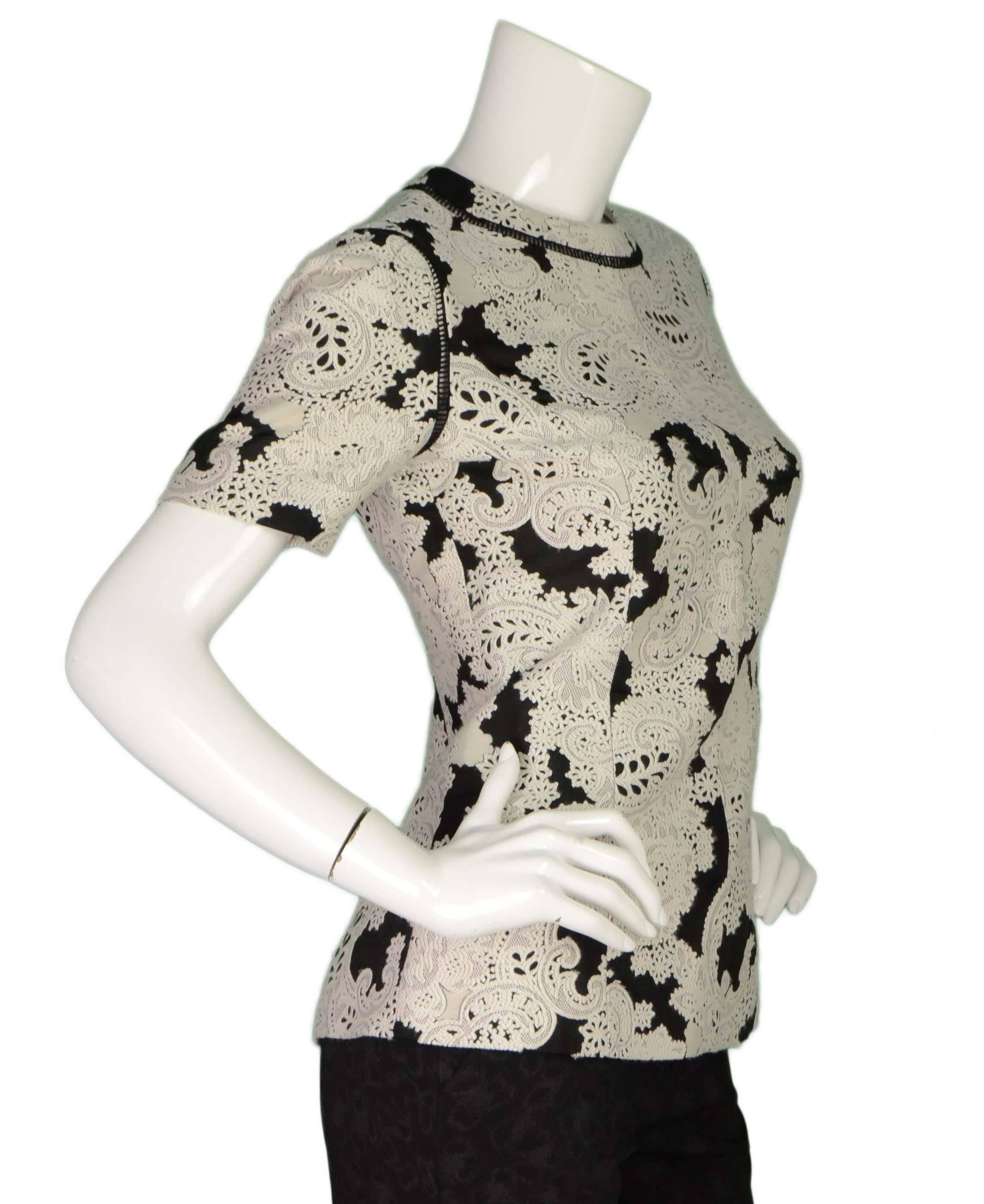 Derek Lam Black & White Paisley Short Sleeve Top 
Features cut out lace detailing at neckline and shoulder seams
Made In: Bulgaria
Color: Black and white
Composition: 45% wool, 39% rayon, 9% silk, 7% polyester
Lining: None
Closure/Opening: