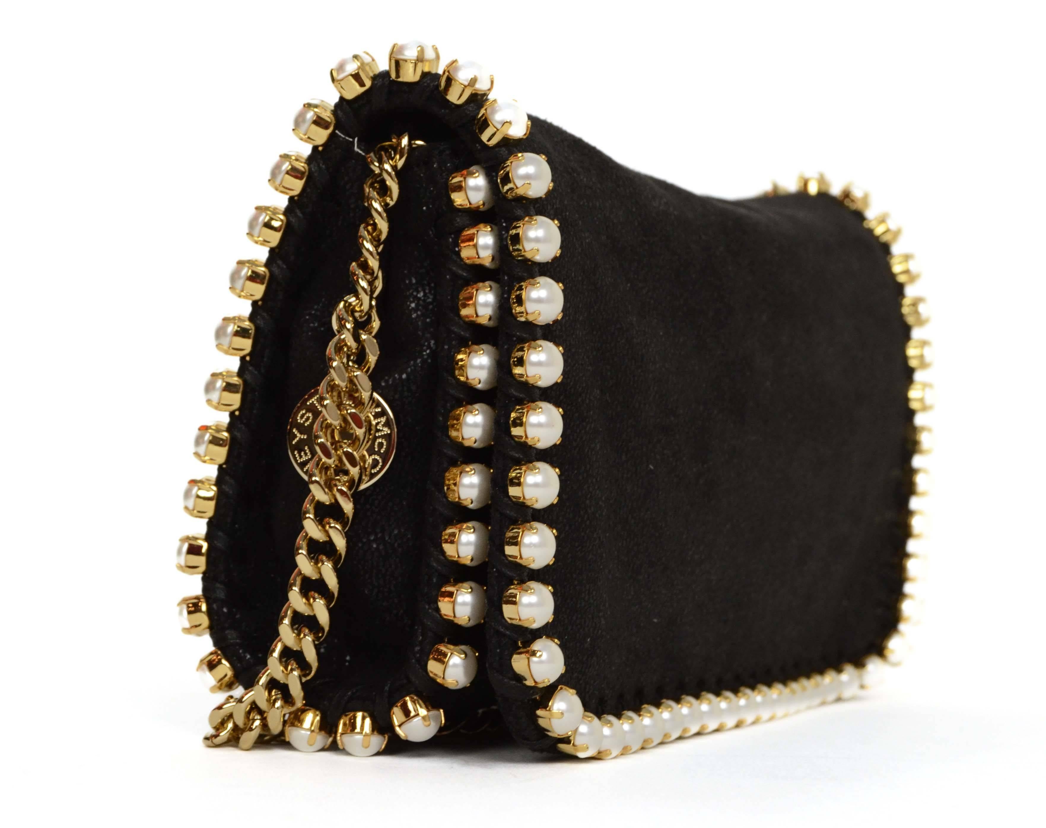 Stella McCartney Black Falabella Pearly-Trim Crossbody Bag 
Features optional chain link strap
Made In: Italy
Color: Black and ivory
Hardware: Goldtone
Materials: Vegan leather, faux pearls and metal
Lining: Dusty pink Stella McCartney logo