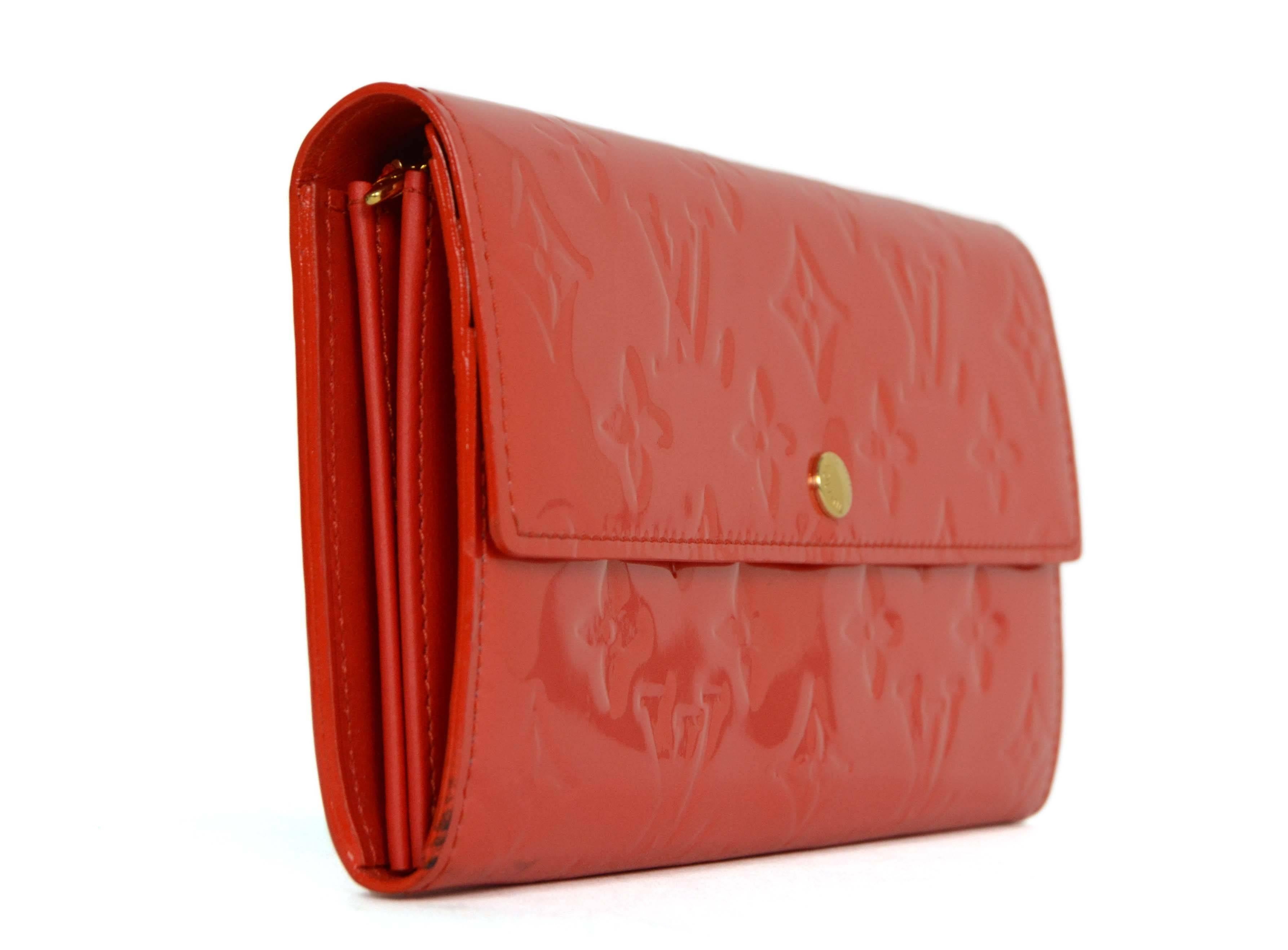 Louis Vuitton Red Vernis Sara Wallet 
Made In: France
Year of Production: 2009
Color: Red
Hardware: Goldtone
Materials: Patent leather and metal
Lining: Red leather
Closure/Opening: Flap top with snap closure
Exterior Pockets: None
Interior