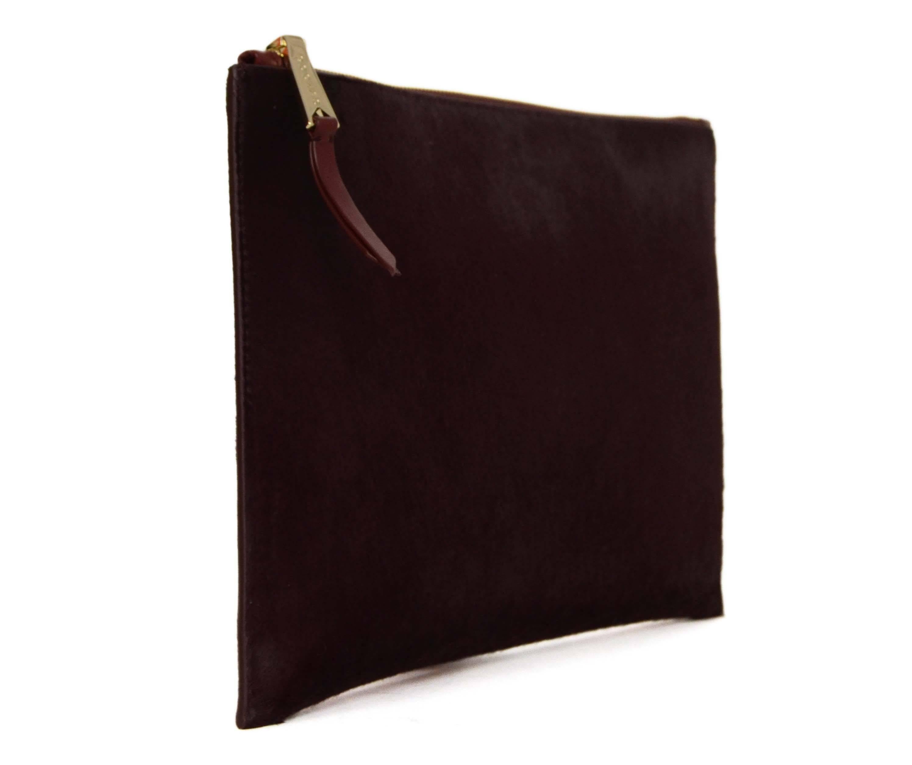 Rochas Burgundy Ponyhair Clutch 
Made In: Italy
Color: Burgundy
Hardware: Goldtone
Materials: Ponyhair
Lining: Black leather
Closure/Opening: Zip across closure
Exterior Pockets: None
Interior Pockets: None
Overall Condition: