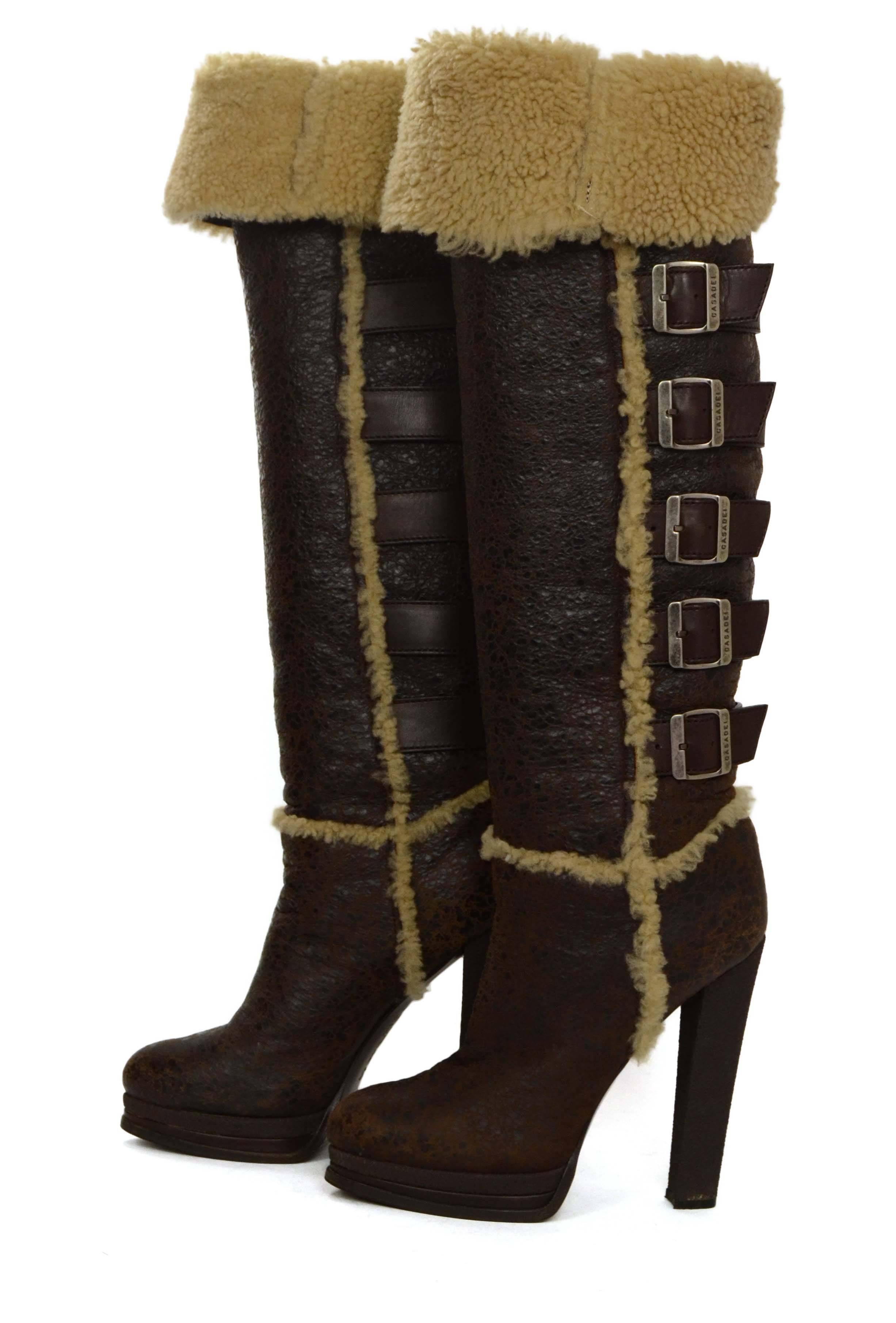 Casadei Brown Shearling Tall Boots 
Features decorative buckles throughout calf
Made In: Italy
Color: Brown and cream
Materials: Distressed leather and shearling
Closure/Opening: Pull on
Sole Stamp: Casadei Made in Italy Vero Cuoio 9
Overall