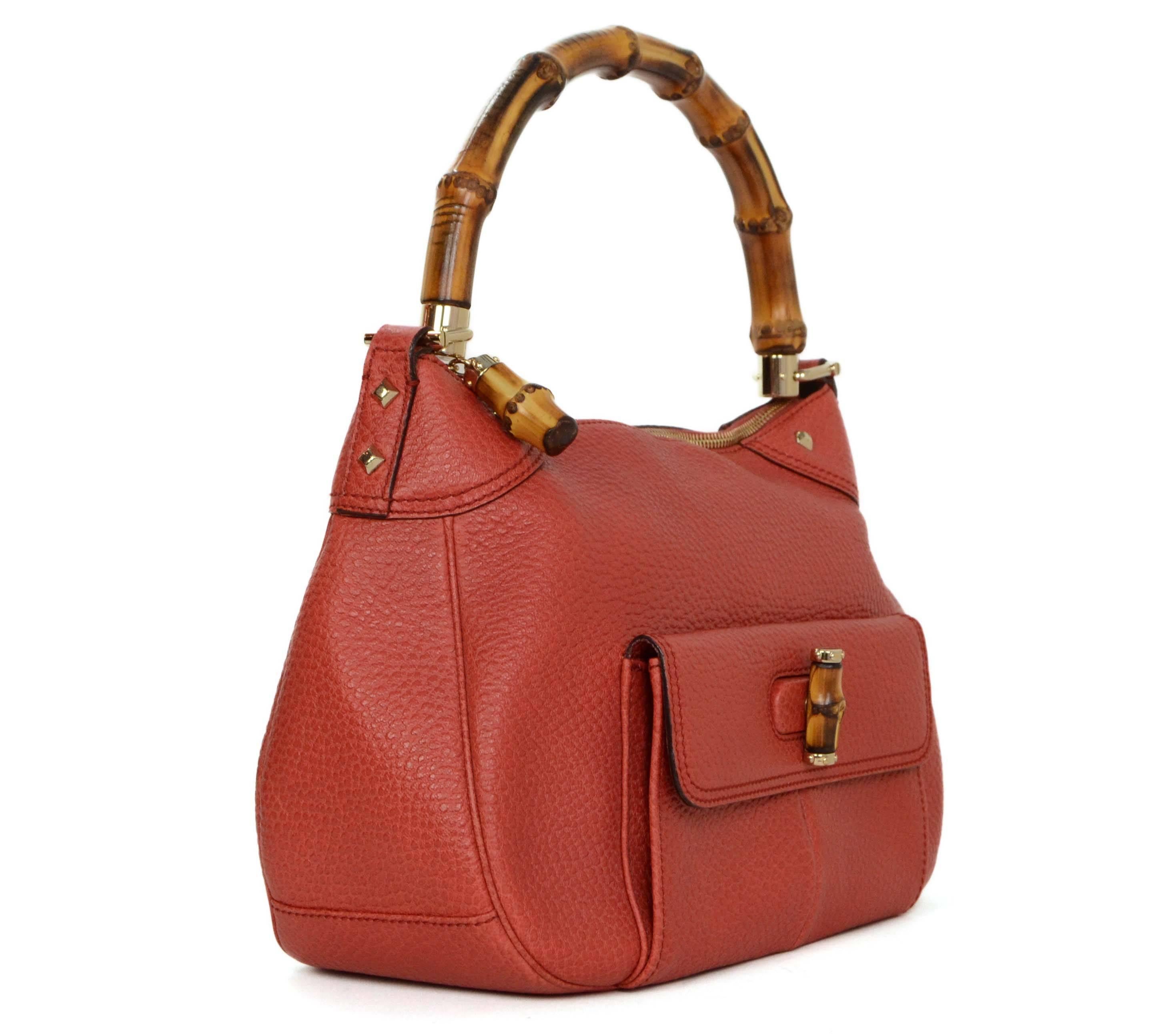 Gucci Orange Leather Bamboo Bag 
Features bamboo handle, zipper pull and front pocket twist lock closure
Made In: Italy
Color: Orange
Hardware: Bamboo and goldtone
Materials: Leather, bamboo and metal
Lining: Brown canvas
Closure/Opening: Zip