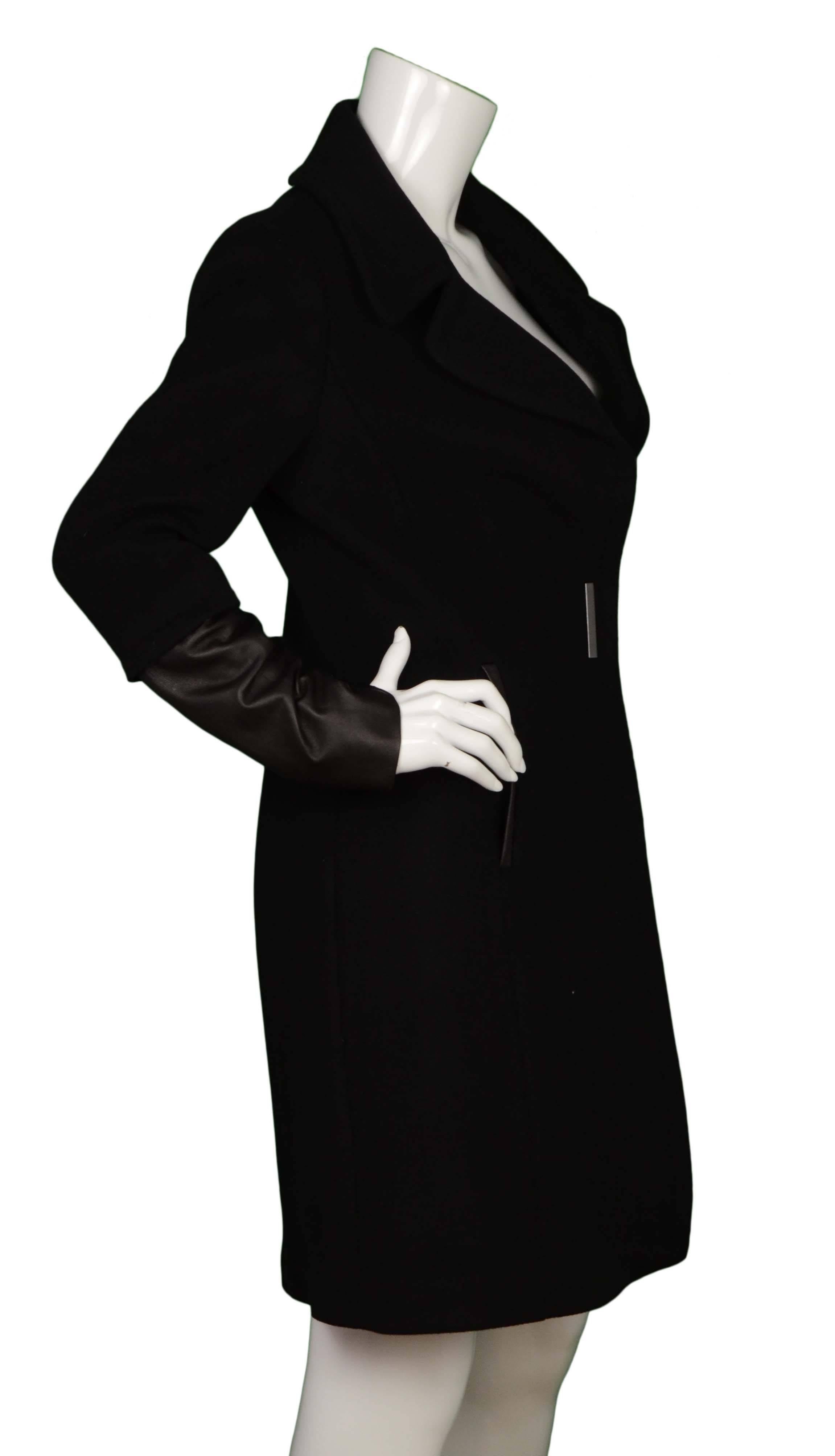 Elie Tahari Black Wool & Leather Coat 
Features leather trim and leather sleeves
Made In: China
Color: Black
Composition: 100% wool, 100% leather
Lining: Navy, 100% polyester
Closure/Opening: Front waist double snap closure
Exterior Pockets: