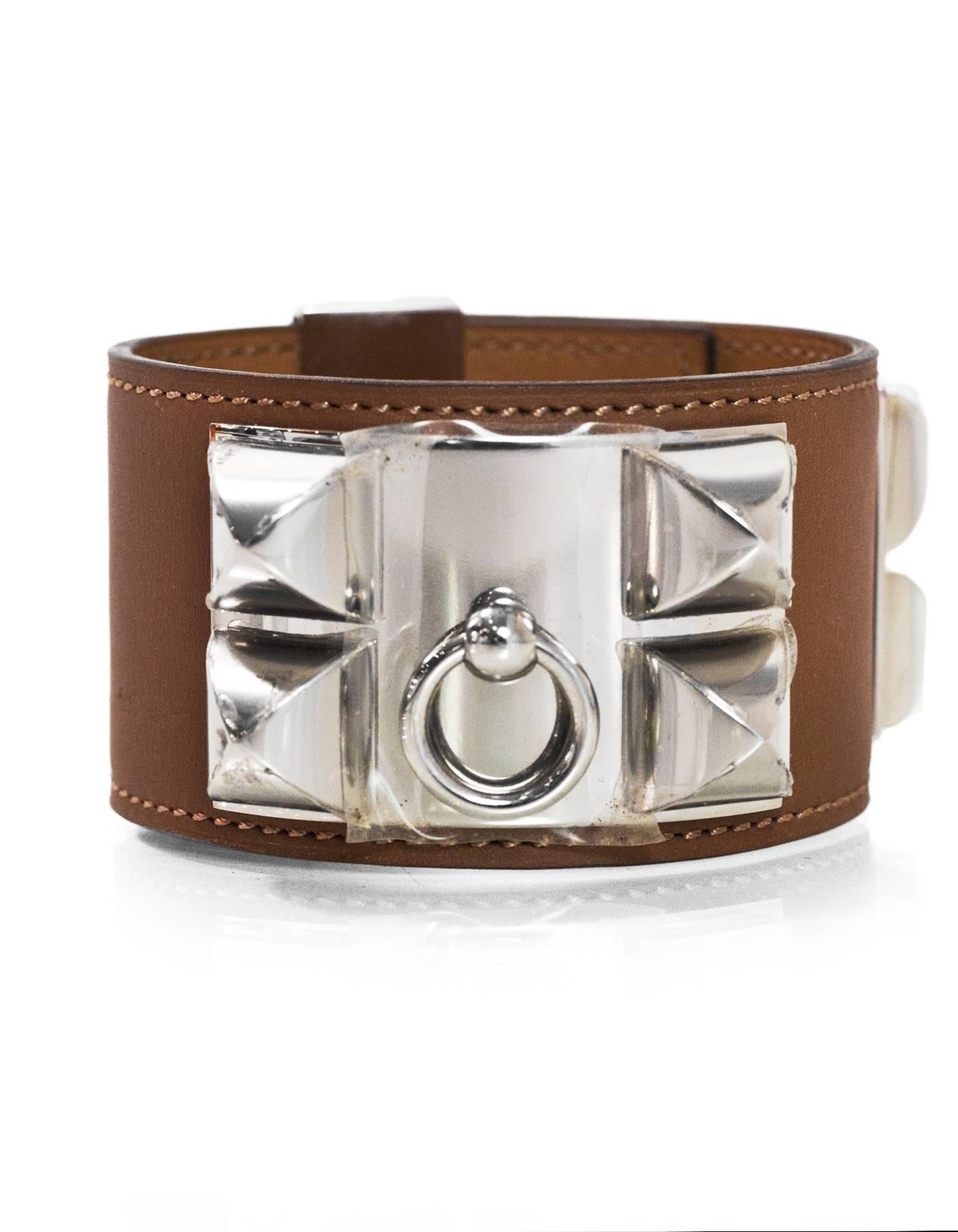 Hermes Tan Barenia Leather CDC Cuff 
Made In: France
Year of Production: 2013
Color: Tan and silver
Hardware: Palladium
Materials: Leather and metal
Closure: Stud and notch closure with sliding bar
Stamp: Q stamp in square
Overall Condition: