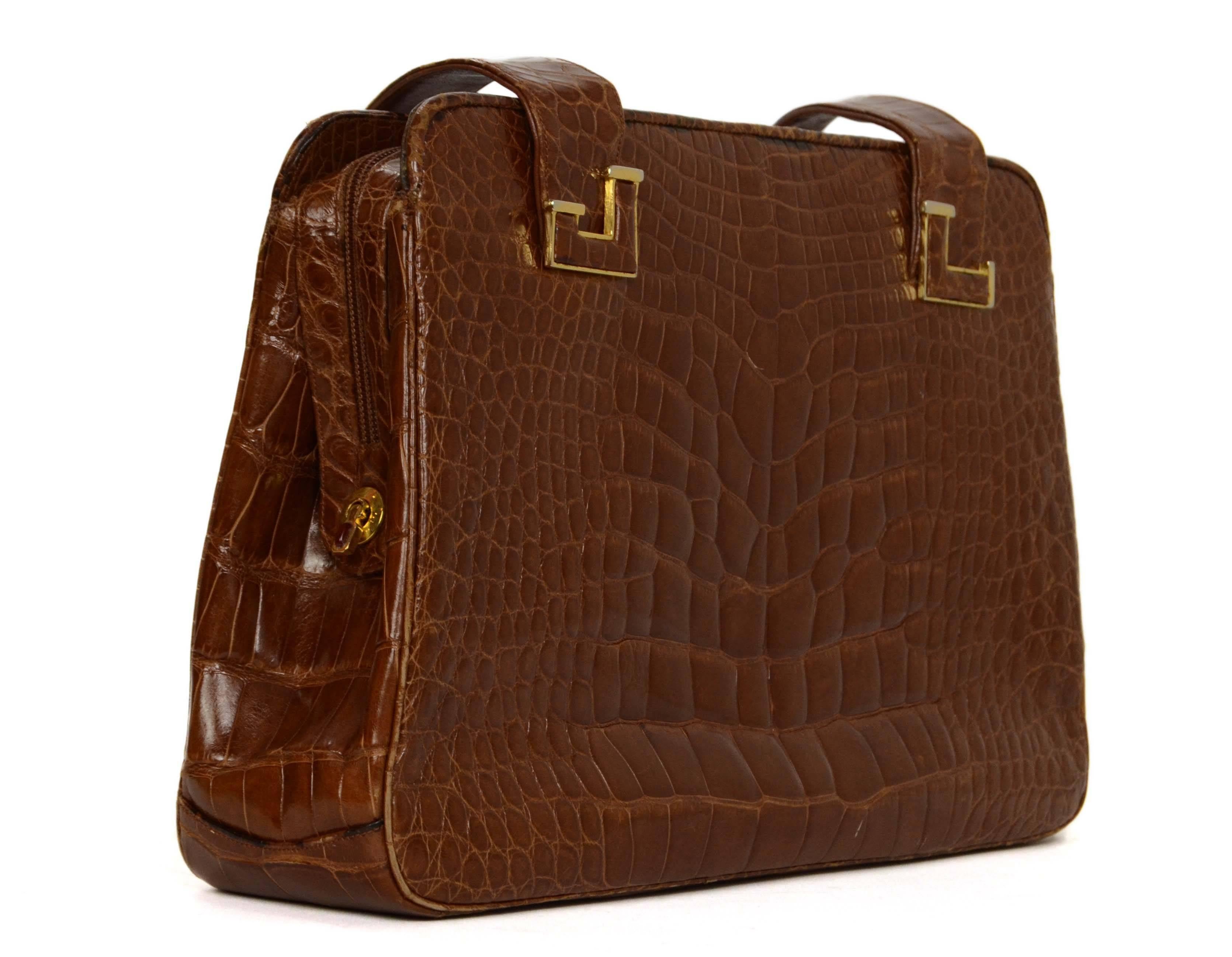 Judith Leiber Brown Alligator Shoulder Bag 
Color: Brown
Hardware: Goldtone
Materials: Alligator
Lining: Brown leather
Closure/Opening: Zip around closure
Exterior Pockets: Two large side compartments both with zipper pockets inside
Interior