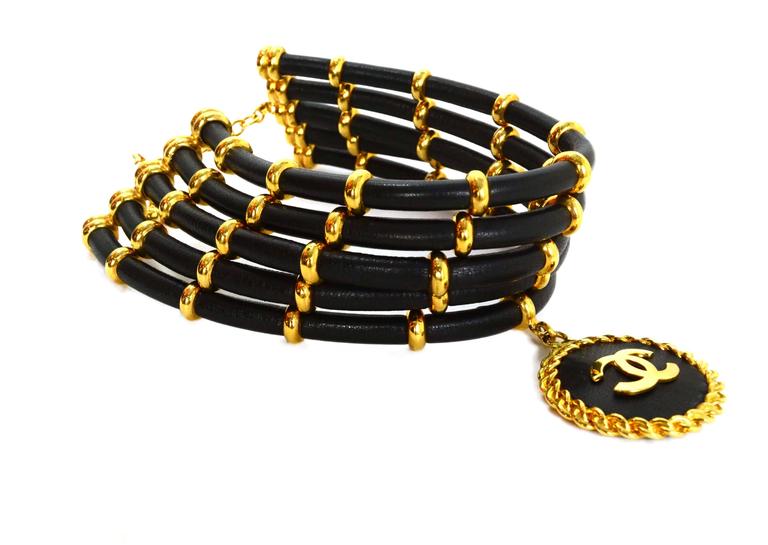 Chanel Vintage '89 Black & Gold Multi-Strand Choker Necklace 
Features large goldtone and black CC pendant
Made In: France
Year of Production: 1989
Color: Black and goldtone
Materials: Leather and metal
Closure: Hook closure
Stamp: 2 CC