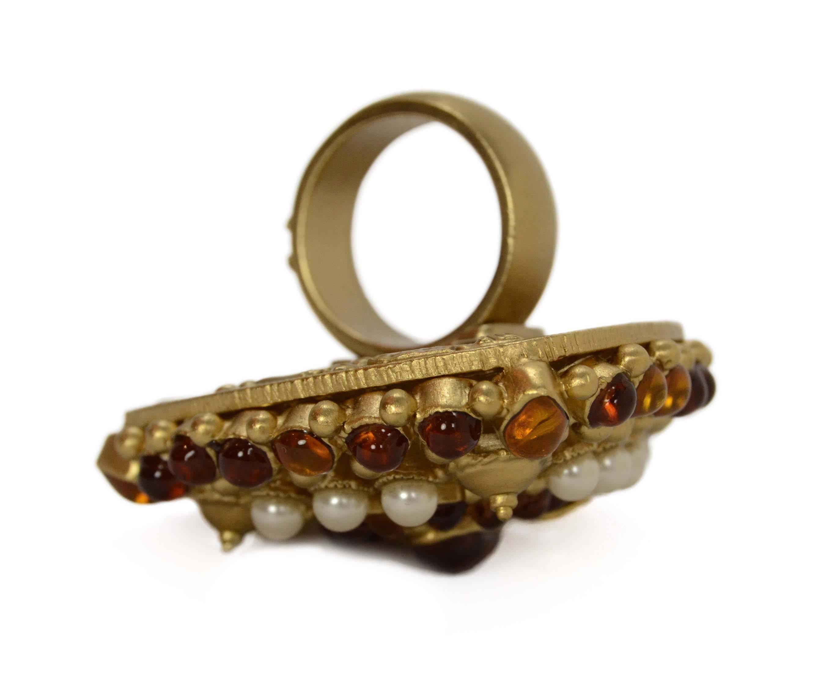 Chanel Amber & Ivory Oversized Cocktail Ring  
Features goldtone CC detailing in center
Made In: France
Year of Production: 2011
Color: Goldtone, ivory and amber
Materials: Glass, faux pearls and metal
Closure: None
Stamp: A11 CC