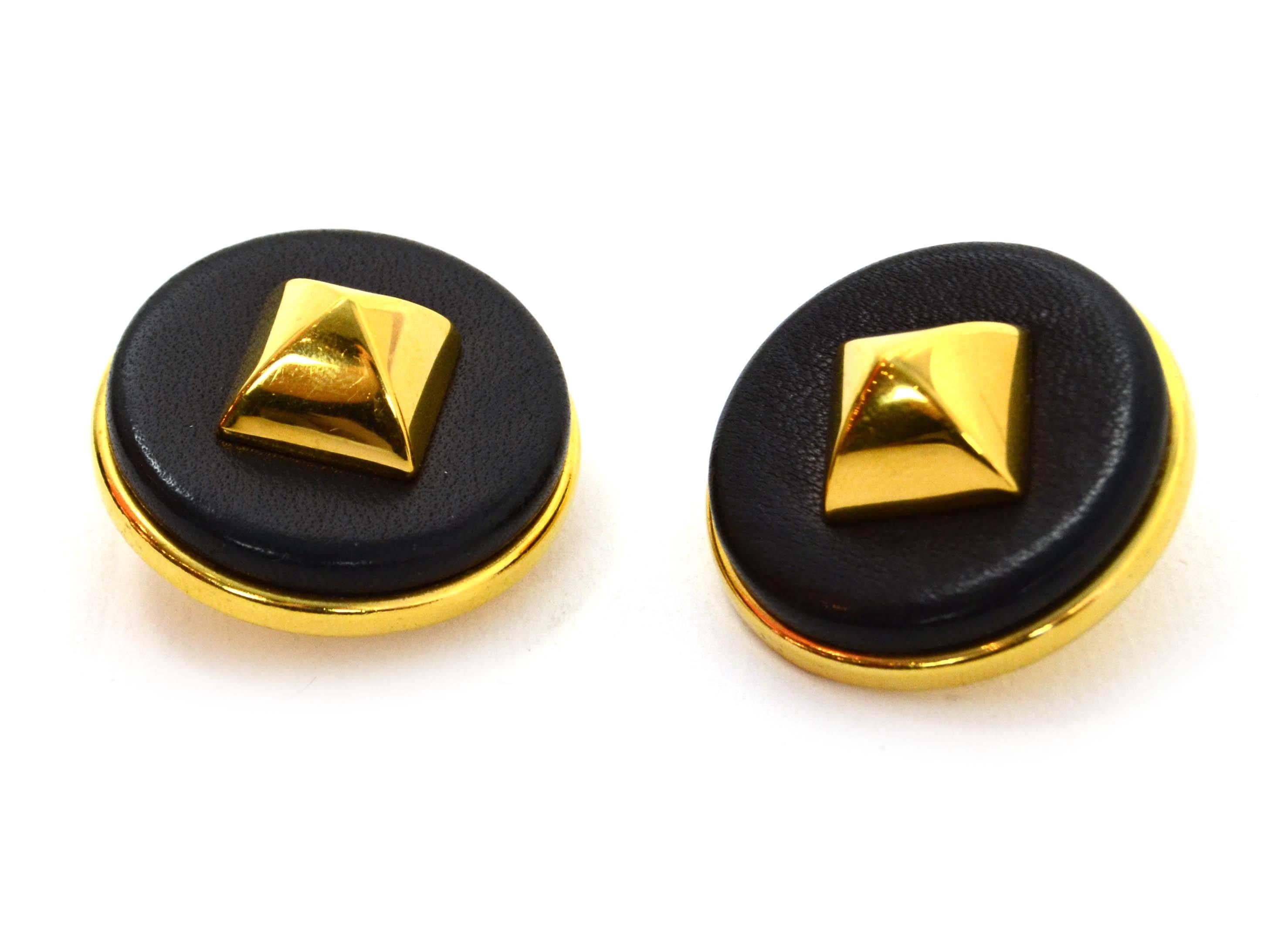 Hermes Black Leather & Gold Medor Clip On Earrings 
Color: Gold and black
Materials: Metal and leather
Closure: Clip on
Stamp: Hermes Paris
Overall Condition: Excellent pre-owned condition
Measurements: 
Diameter: 1.5"