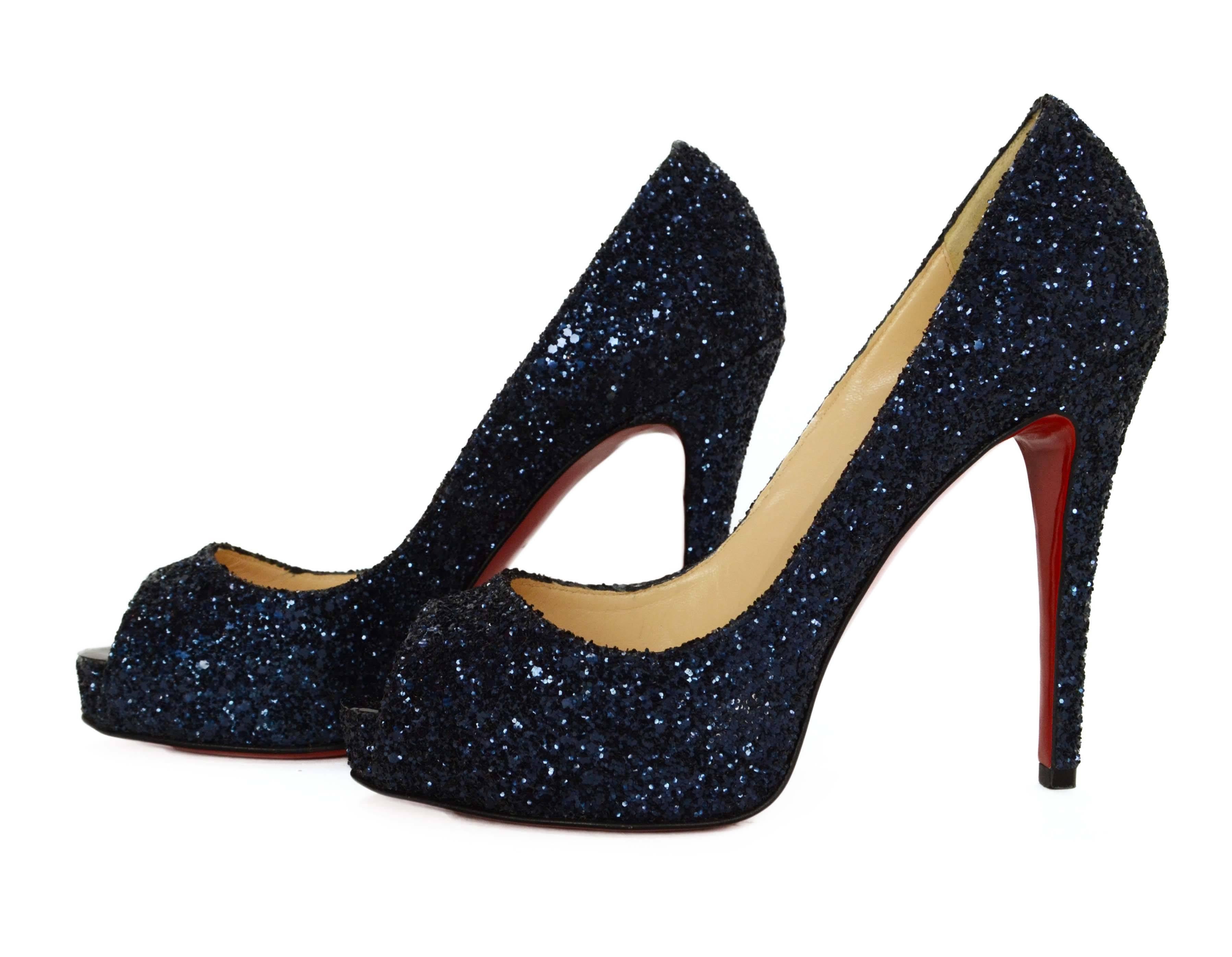 Christian Louboutin Very Prive Glitter Peep-Toe Pumps 
Features hidden platform
Made In: Italy
Color: Navy
Materials: Glitter and leather
Closure/Opening: Slide on
Sole Stamp: Christian Louboutin Made in Italy 37
Overall Condition: Excellent-