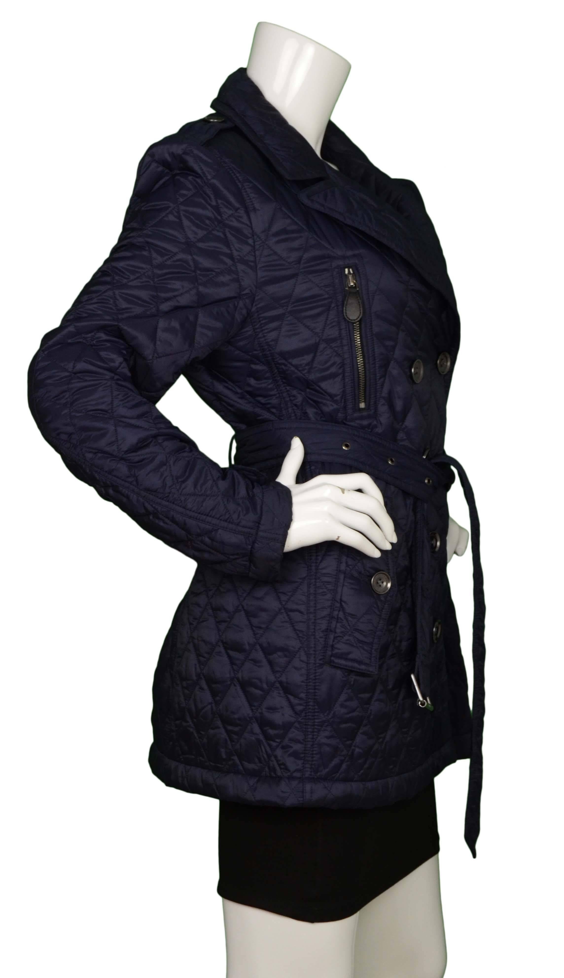 Burberry Brit Navy Quilted Nylon Jacket 
Features optional waist belt
Made In: China
Color: Navy
Composition: 100% polyester
Lining: Navy & black plaid, 100% polyester
Closure/Opening: Double breasted button down closure
Exterior Pockets: Two