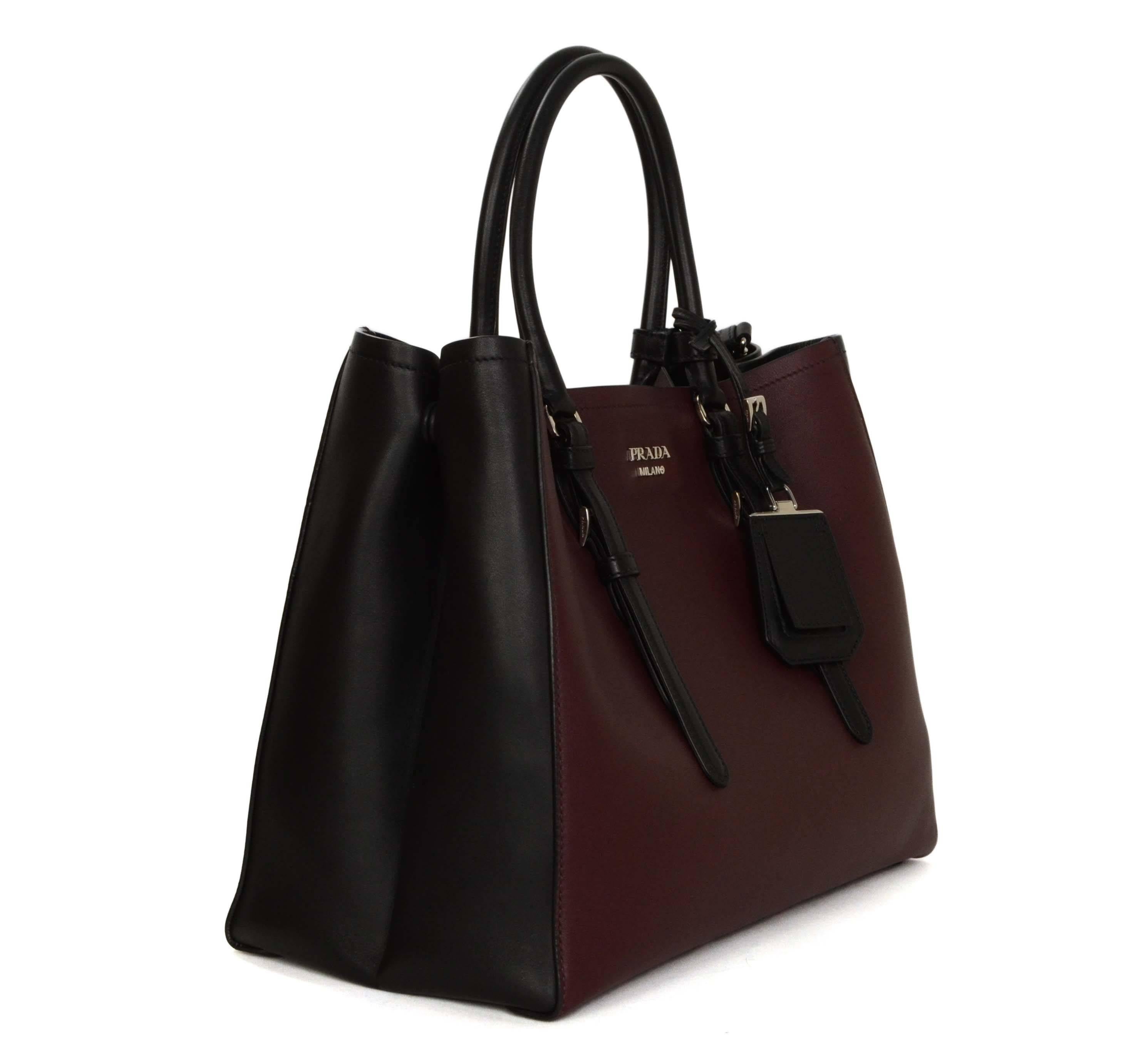 Prada '15 Black & Burgundy Calfskin City Double Tote
Features expandable sides and optional shoulder strap
Made In: Italy
Color: Burgundy and black
Hardware: Silvertone
Materials: Leather
Lining: Black leather
Closure/Opening: Open