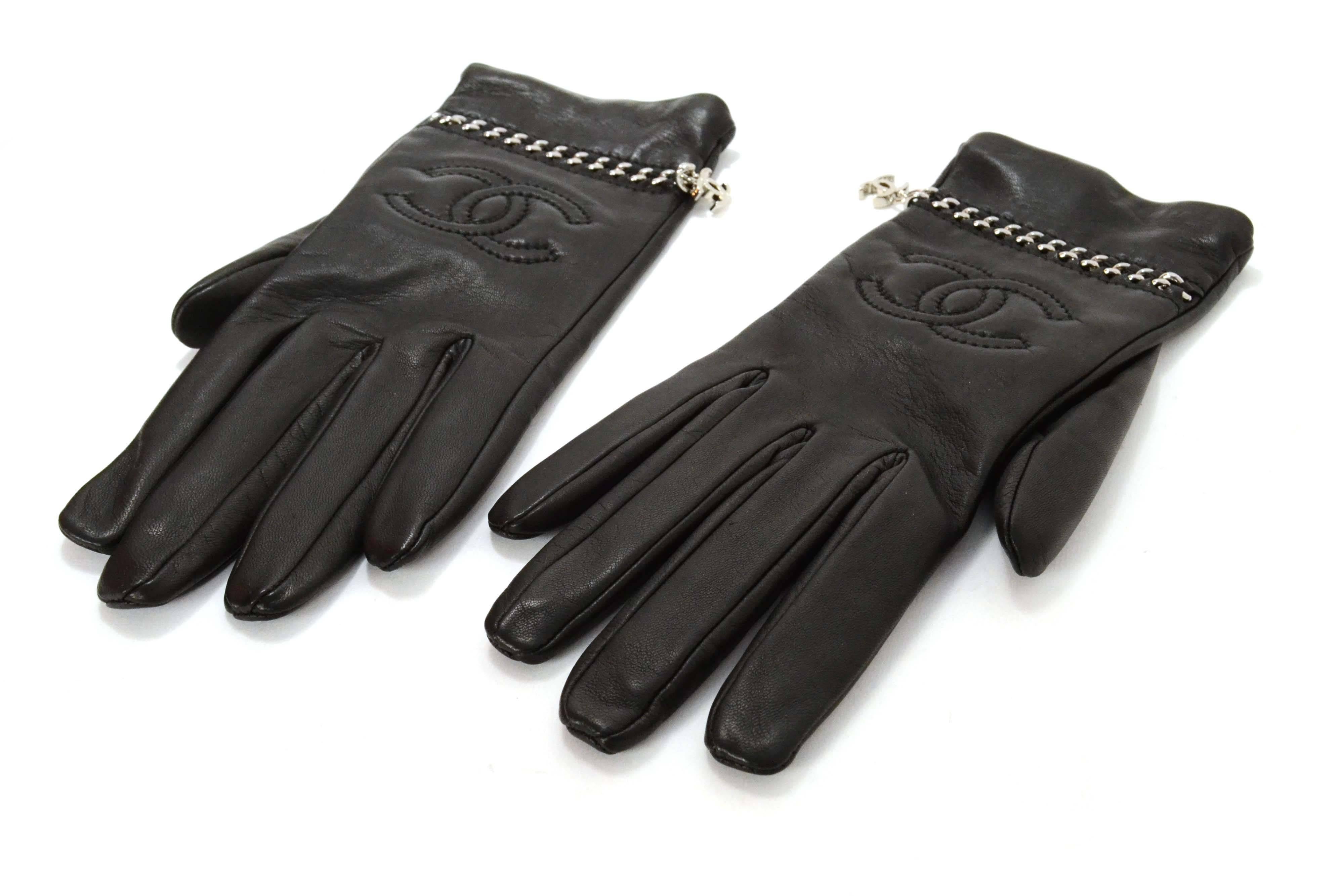 Chanel Black Leather & Silver Chain Through Gloves 
Features stitched CC's on top of hands as well as CC charm attached to silver chain
Made In: France
Year of Production: 2010
Color: Black and silvertone
Composition: 100% leather with metal