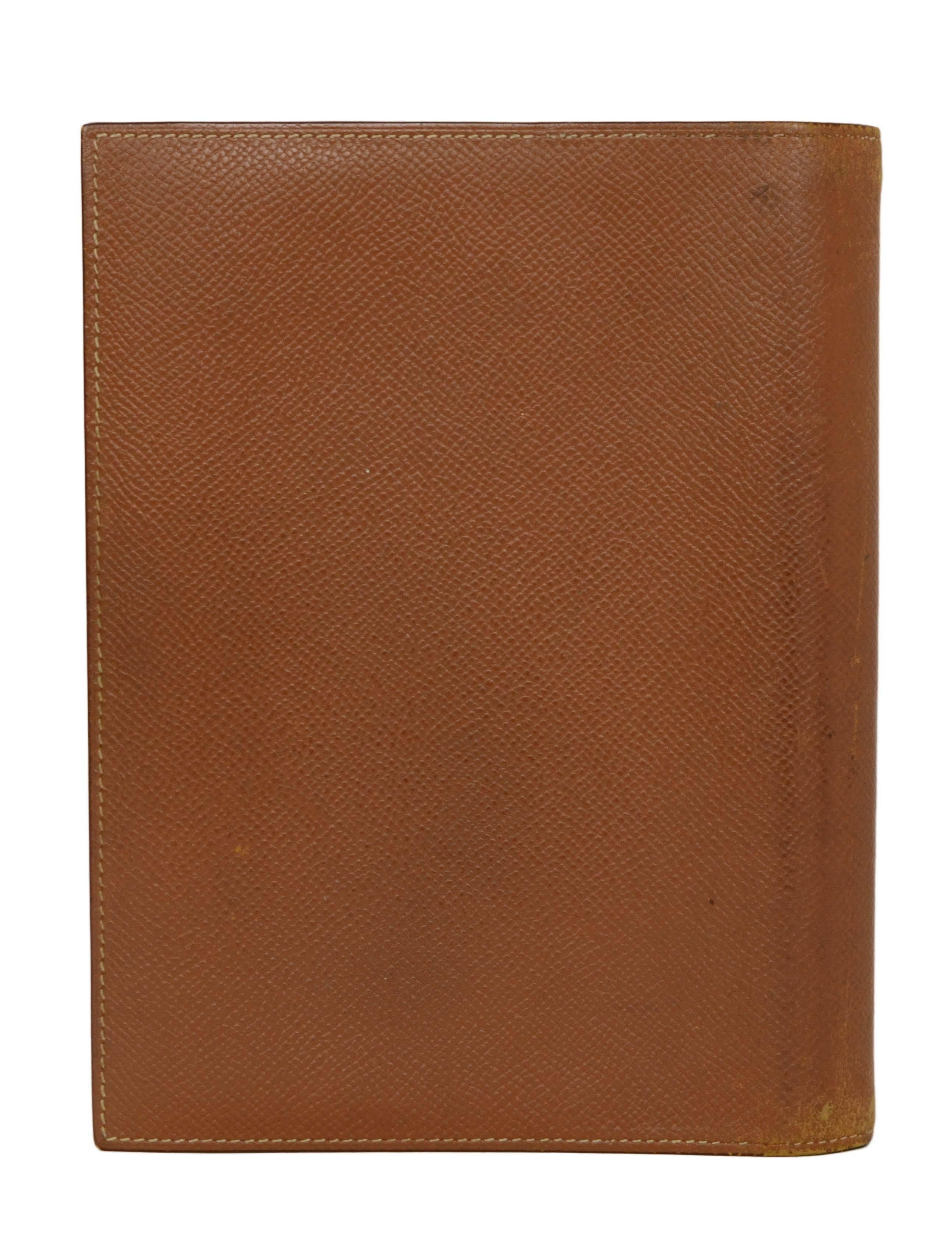 Hermes Vintage '99 Tan Leather Agenda Cover 
Made In: France
Year of Production: 1999
Color: Tan
Hardware: Palladium
Materials: Leather and metal
Lining: Tan leather
Closure: Bi-fold
Exterior Pockets: None
Interior Pockets: One vertical