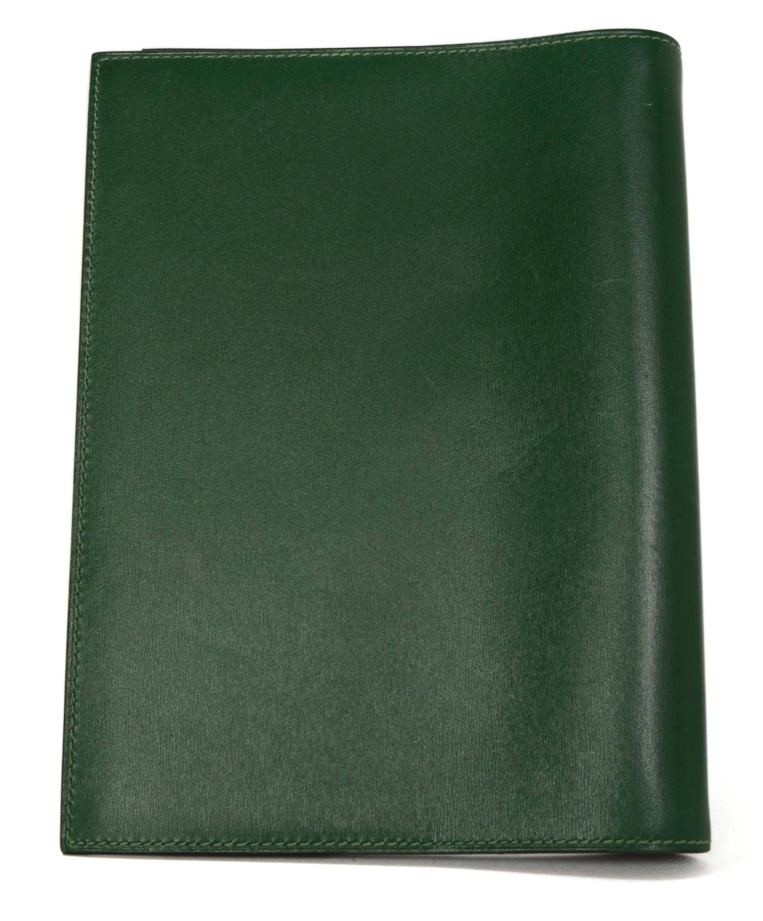 Hermes Green Leather Agenda Cover 
Made In: France
Year of Production: 2000
Color: Green
Hardware: Palladium
Materials: Leather and metal
Lining: Green leather
Closure: Bi-fold
Exterior Pockets: None
Interior Pockets: One vertical