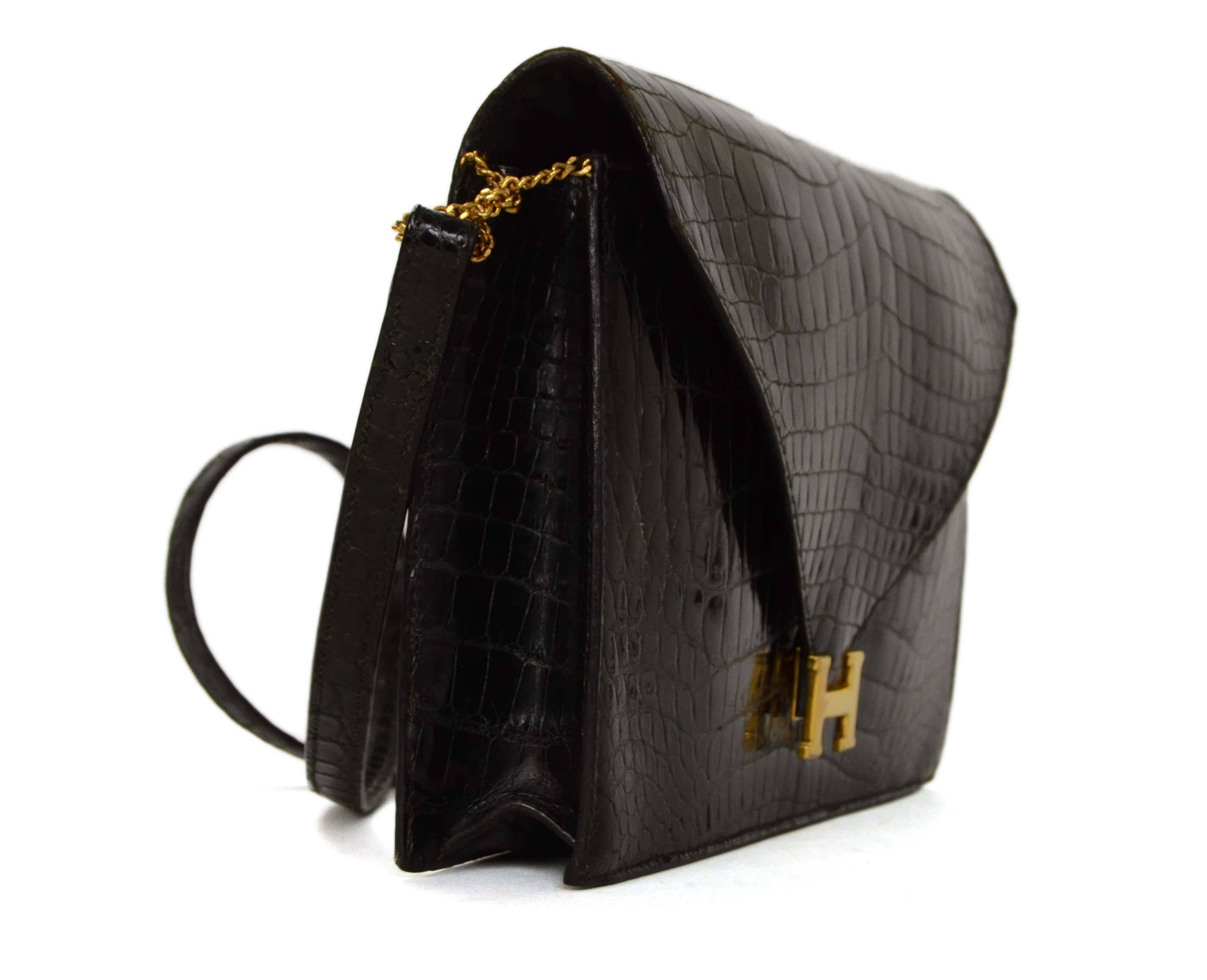 Hermes Black Crocodile Sac Lydie H Clutch 
Features optional shoulder strap
Made In: France
Color: Black
Hardware: Goldtone
Materials: Crocodile and metal
Lining: Black leather
Closure/Opening: Flap top with snap button closure
Exterior