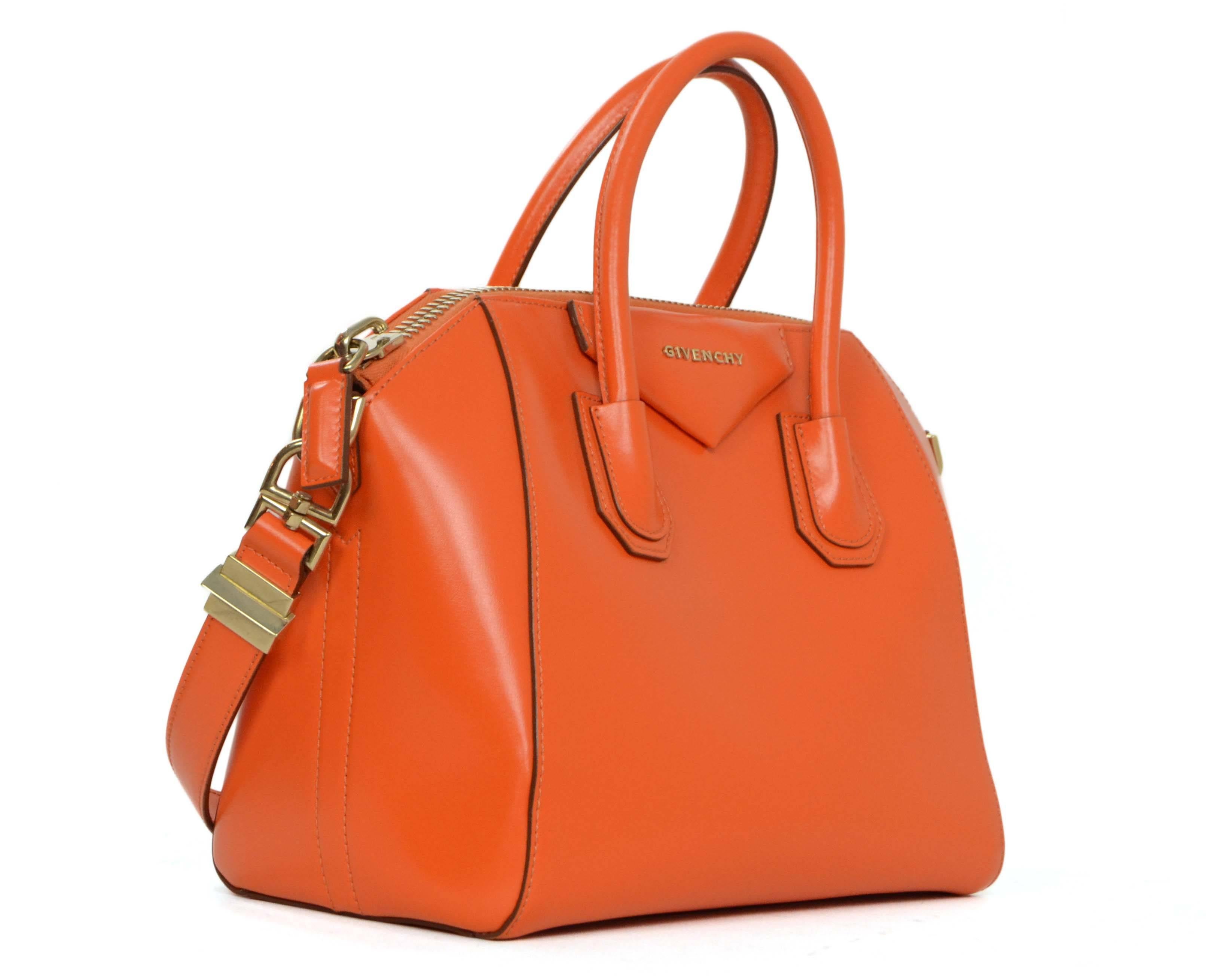 Givenchy Orange Leather Small Antigona Bag 
Made In: Italy
Color: Orange
Hardware: Goldtone
Materials: Leather and metal
Lining: Beige canvas
Closure/Opening: Zip around closure
Exterior Pockets: None
Interior Pockets: One zipper pocket, one