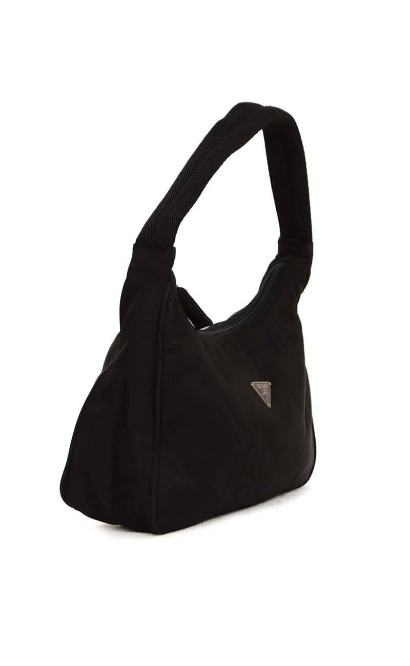 Prada Small Black Nylon Shoulder Bag
Made In: Italy
Color: Black
Hardware: Silvertone
Materials: Nylon
Lining: Black nylon
Closure/Opening: Zip across top
Exterior Pockets: None
Interior Pockets: None
Serial Number/Date Code: 130
Overall