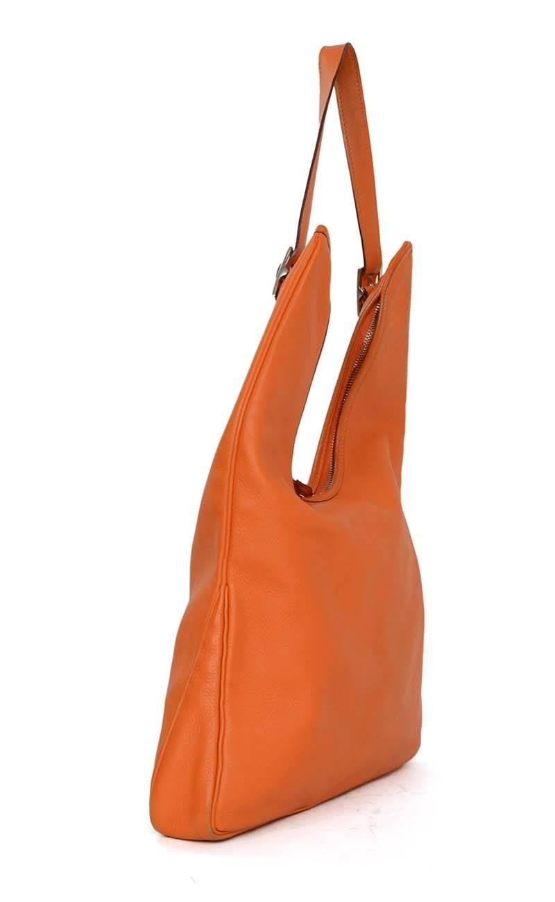 Hermes Orange Leather 'Massai' Bag 
Made In: France
Year of Production: 2006
Color: Orange
Hardware: Palladium
Materials: Leather
Lining: Beige canvas
Closure/Opening: Top double sided zip closure
Exterior Pockets: None
Interior Pockets: