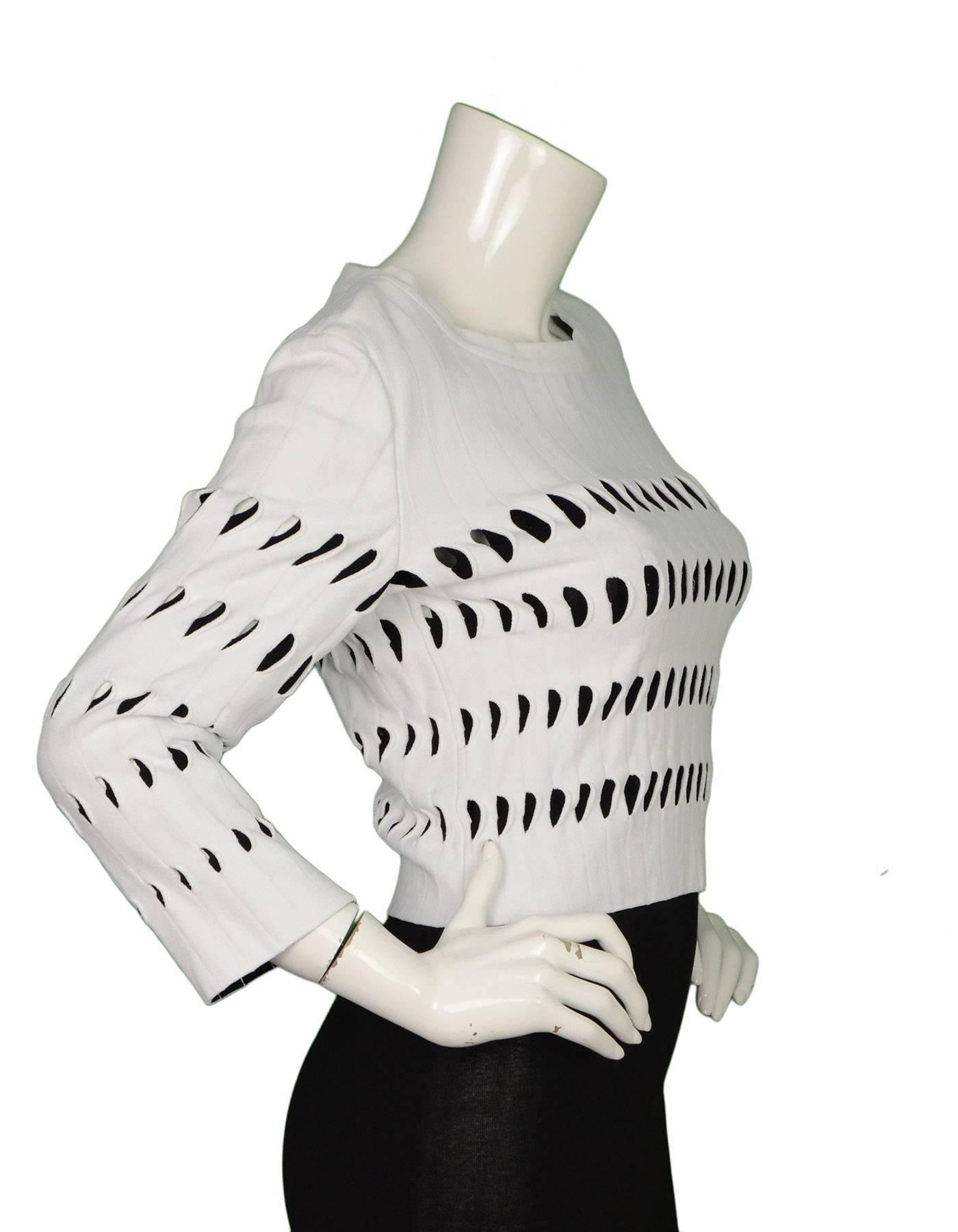 Alaia White & Black Cut-Out Cropped Top 
Features black underlay at cutouts
Made In: Italy
Color: White and black
Composition: 83% viscose, 17% polyester
Lining: None
Closure/Opening: Side zipper
Exterior Pockets: None
Interior Pockets: