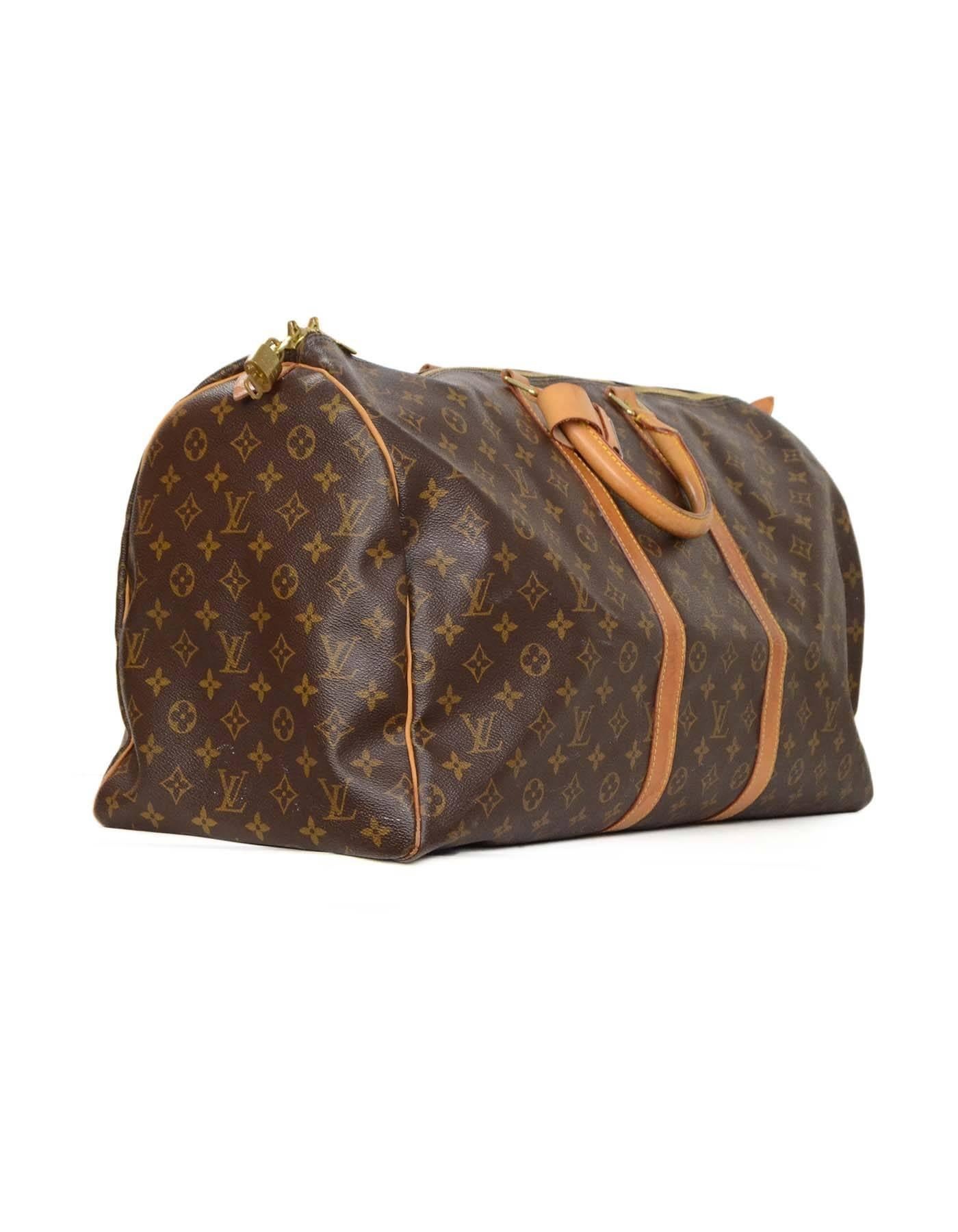 Louis Vuitton Monogram Keepall 55 Luggage 
Features leather wrapped handles and leather trim
Made In: France
Year of Production: 2001
Color: Brown and tan
Hardware: Goldtone
Materials: Coated canvas
Lining: Brown canvas
Closure/Opening: Zip
