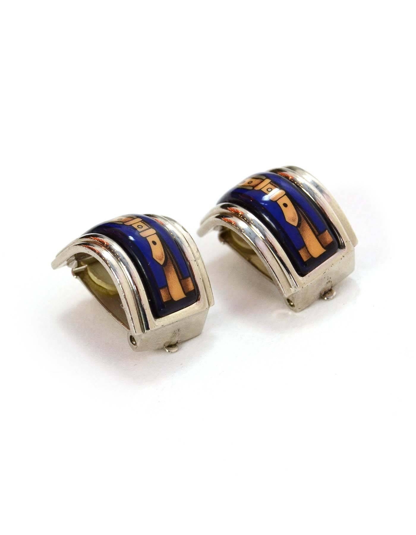 Hermes Blue Enamel Clip On Earrings 
Featurse tan buckle printed in center of blue enamel
Color: Blue, tan and silvertone
Materials: Palladium and enamel
Closure: Clip on
Stamp: Hermes
Overall Condition: Excellent pre-owned