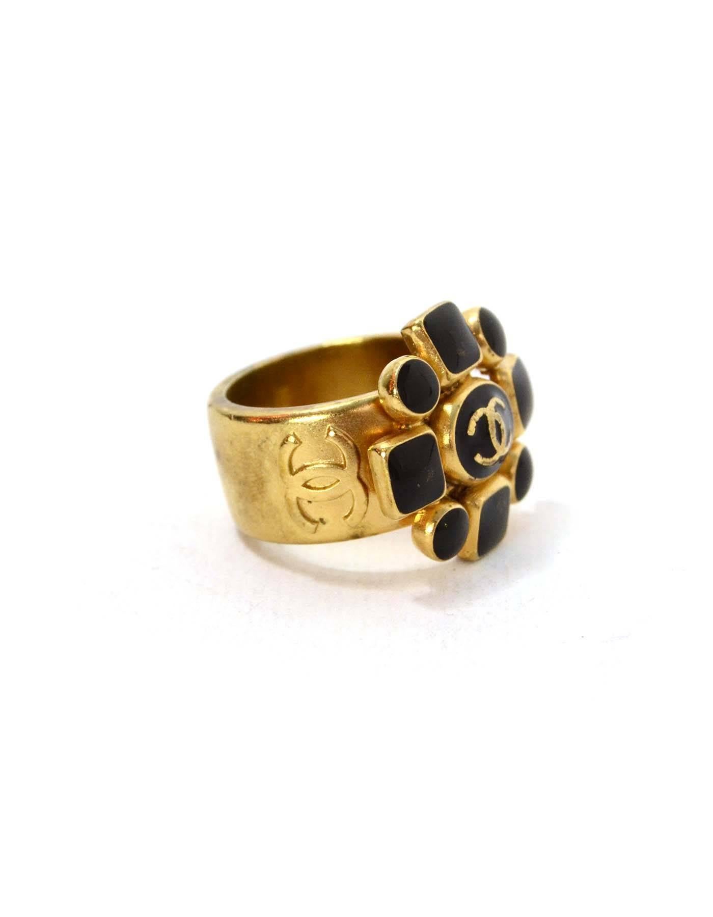 Chanel Gold & Black Flower Cocktail Ring 
Features CC in center of flower pendant
Made In: France
Year of Production: 2007
Color: Black and goldtone
Materials: Metal and enamel
Closure: None
Stamp: 07 CC A
Overall Condition: Excellent