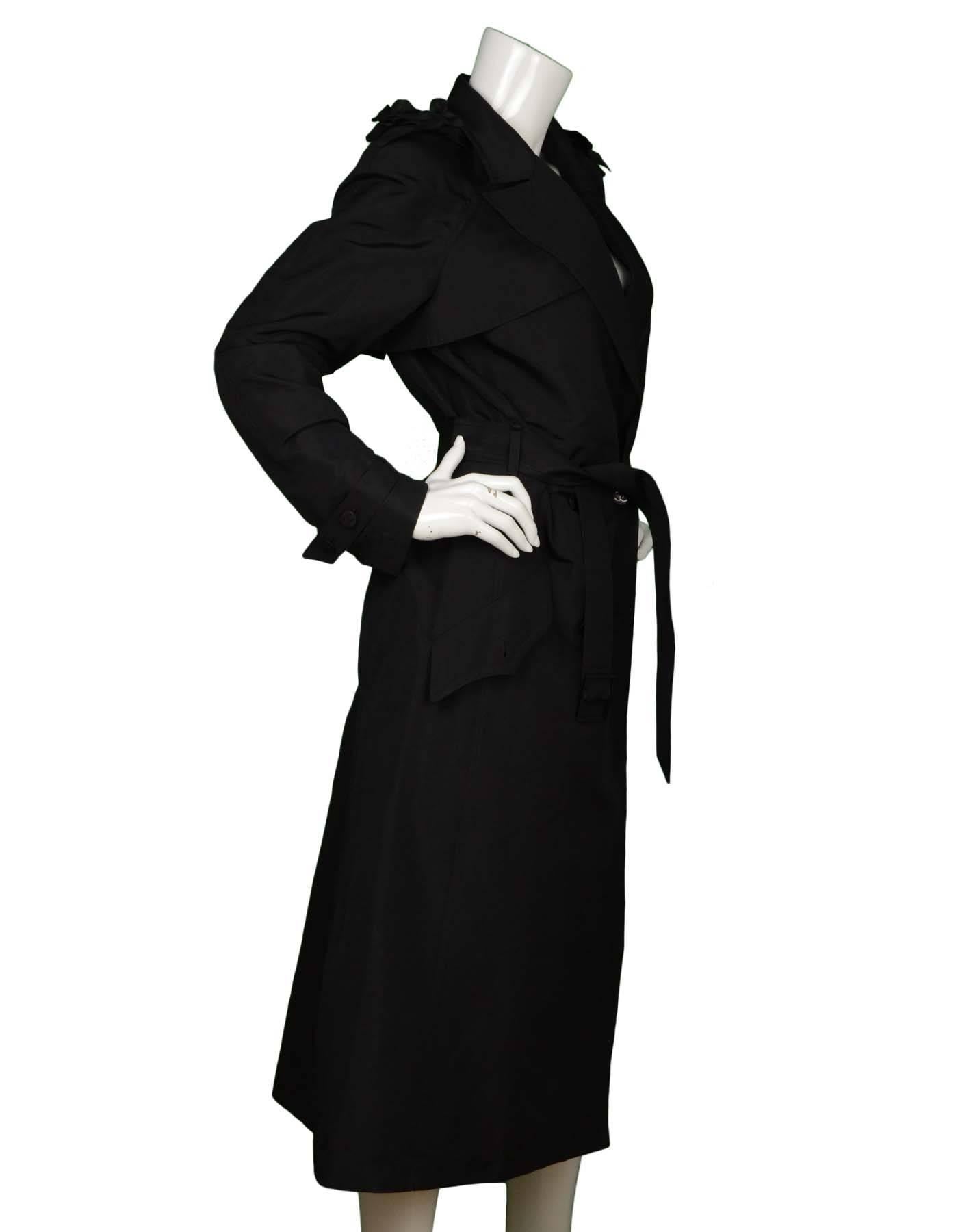 Chanel Black Silk Long Belted Trench Coat 
Features camelia flower appliques at shoulders
Made In: France
Year of Production: 2003
Color: Black
Composition: 100% silk
Lining: None
Closure/Opening: Double breasted button front closure with