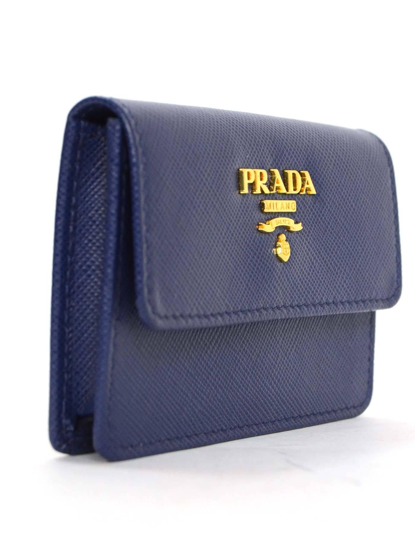 Prada Blue Saffiano Card Holder 
Features goldtone Prada logo on flap top
Made In: Italy
Color: Blue
Hardware: Goldtone
Materials: Saffiano leather
Closure/Opening: Flap top with snap closure
Exterior Pockets: None
Interior Pockets: