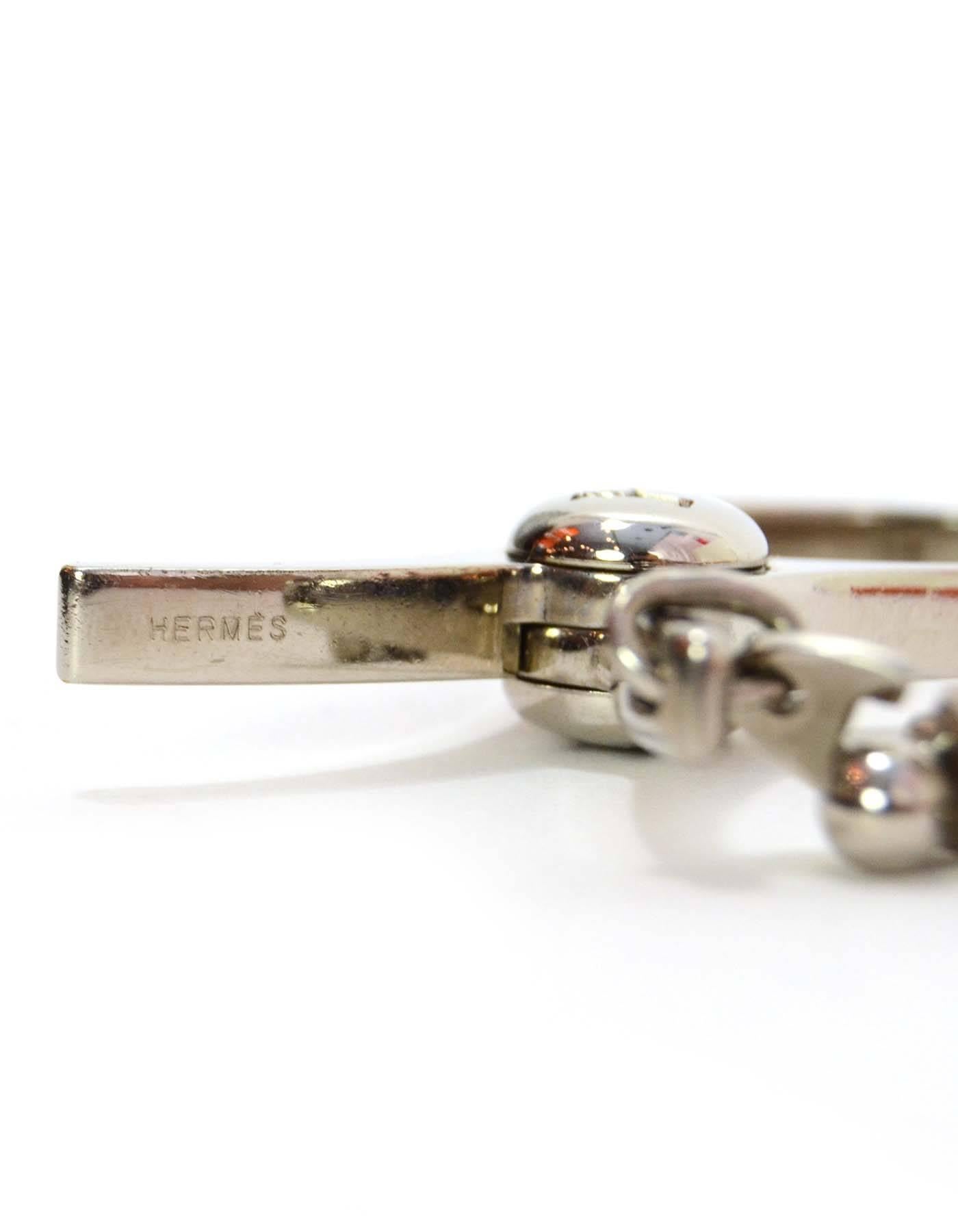 Hermes Silver Filou Glove Clip 
Features H engraved on push lever
Color: Silvertone
Materials: Metal
Closure/Opening: Push hinge
Stamp: Hermes
Retail Price: $335 + tax
Overall Condition: Excellent pre-owned condition
Includes: Hermes