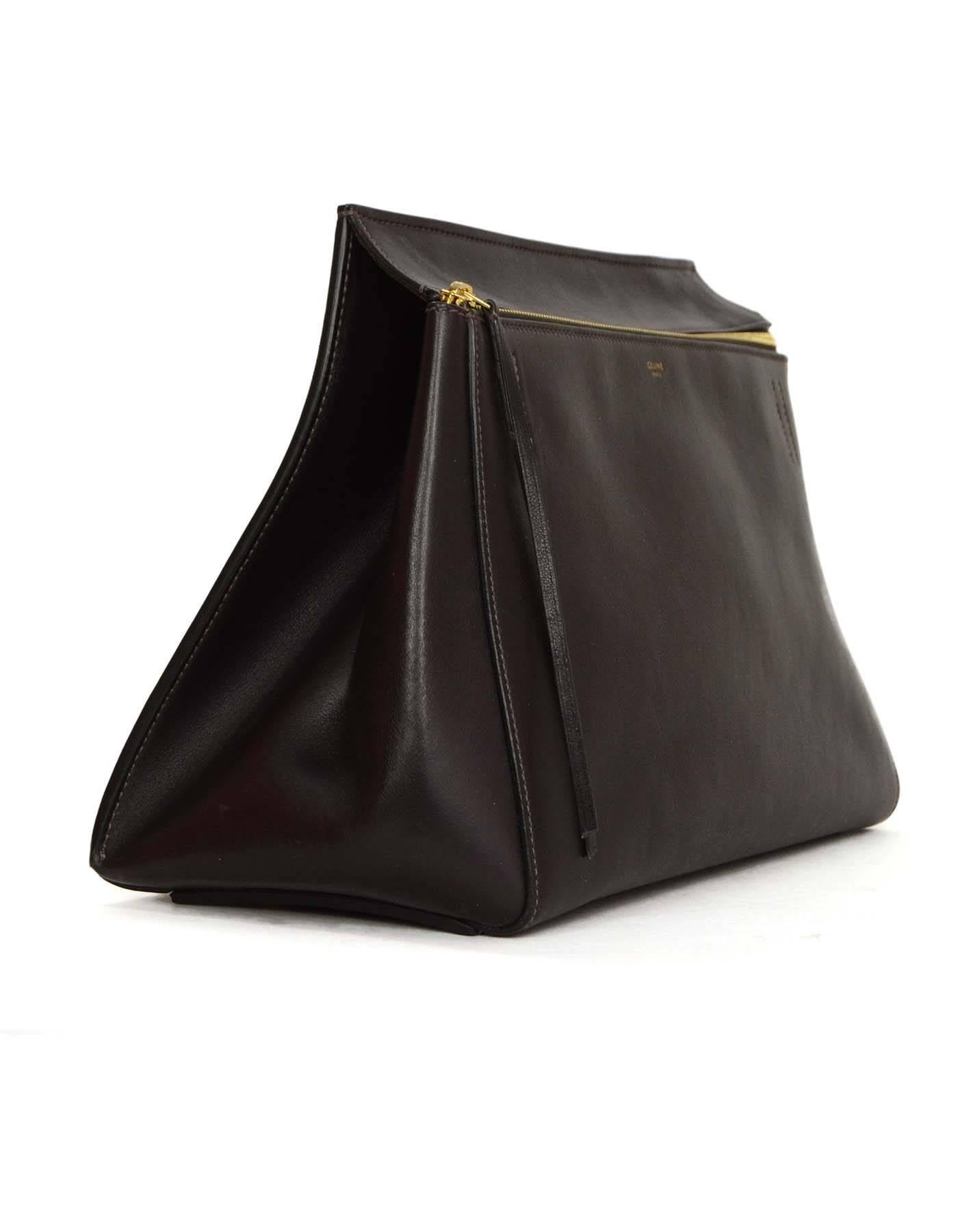Celine Brown Leather 'Edge' Tote
Made In: Italy
Color: Dark brown
Hardware: Goldtone
Materials: Leather
Lining: Brown suede
Closure/Opening: Zip across top
Exterior Pockets: Back patch pocket
Interior Pockets: Two flat pockets, and one