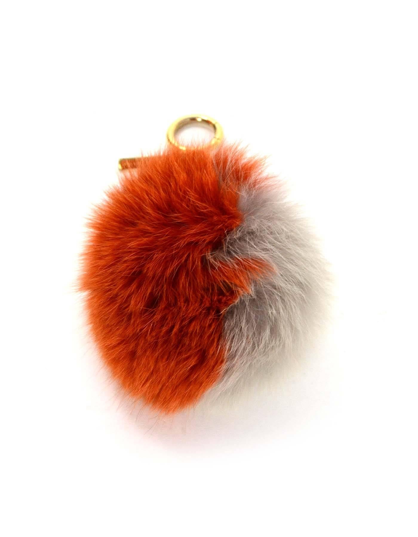 Fendi Grey & Orange Fox Fur Pom Pom 
Features orange textured leather strap
Made In: Italy
Color: Orange and grey
Hardware: Goldtone
Materials: Fox fur, leather, and metal
Closure/Opening: Jump ring with push hinge
Stamp: Fendi Made in