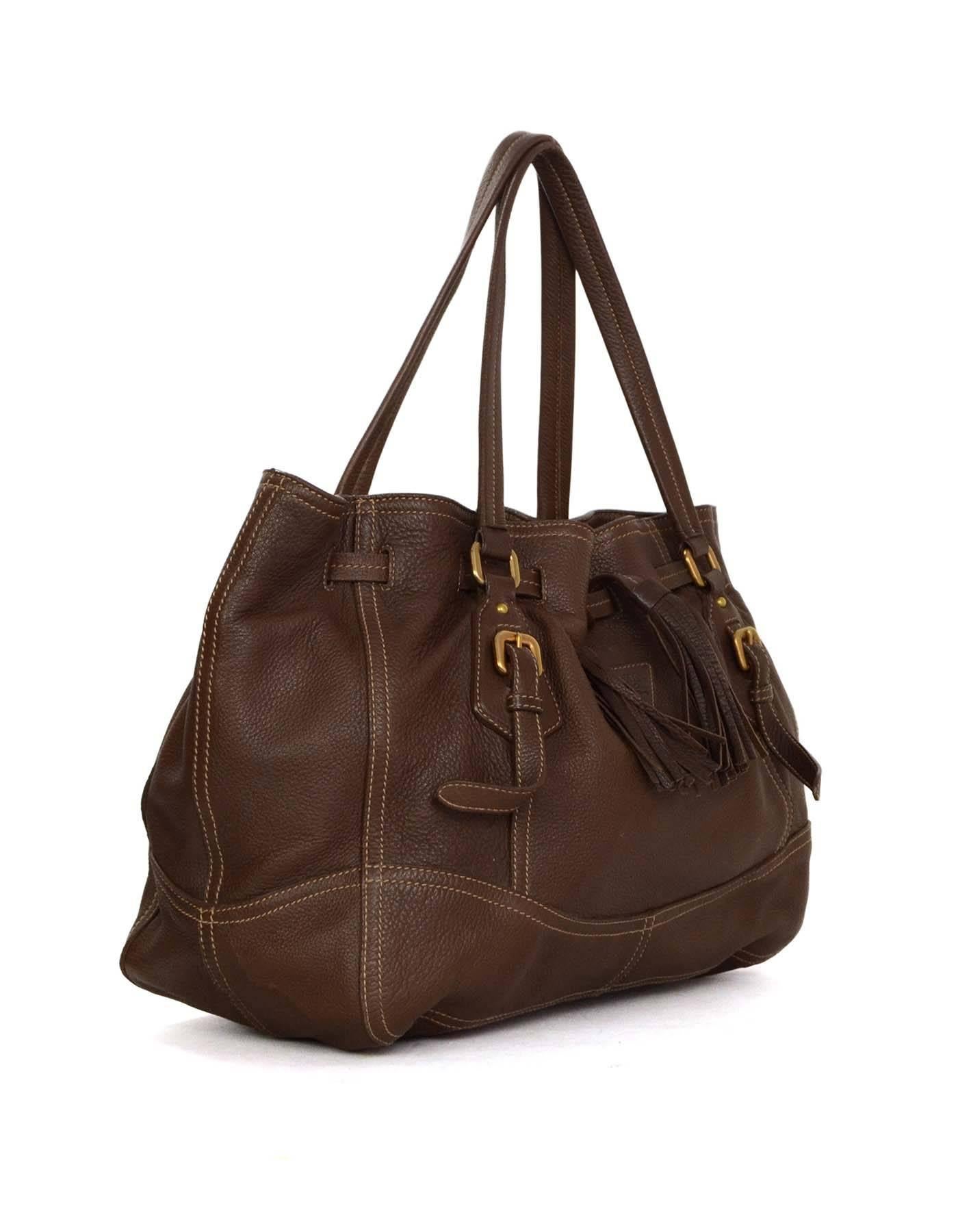 Prada Brown Leather Drawstring Tote 
Made In: Italy
Color: Brown
Hardware: Goldtone
Materials: Leather
Lining: Beige canvas
Closure/Opening: Drawstring closure 
Exterior Pockets: None
Interior Pockets: One zipper pocket, one flat pocket and