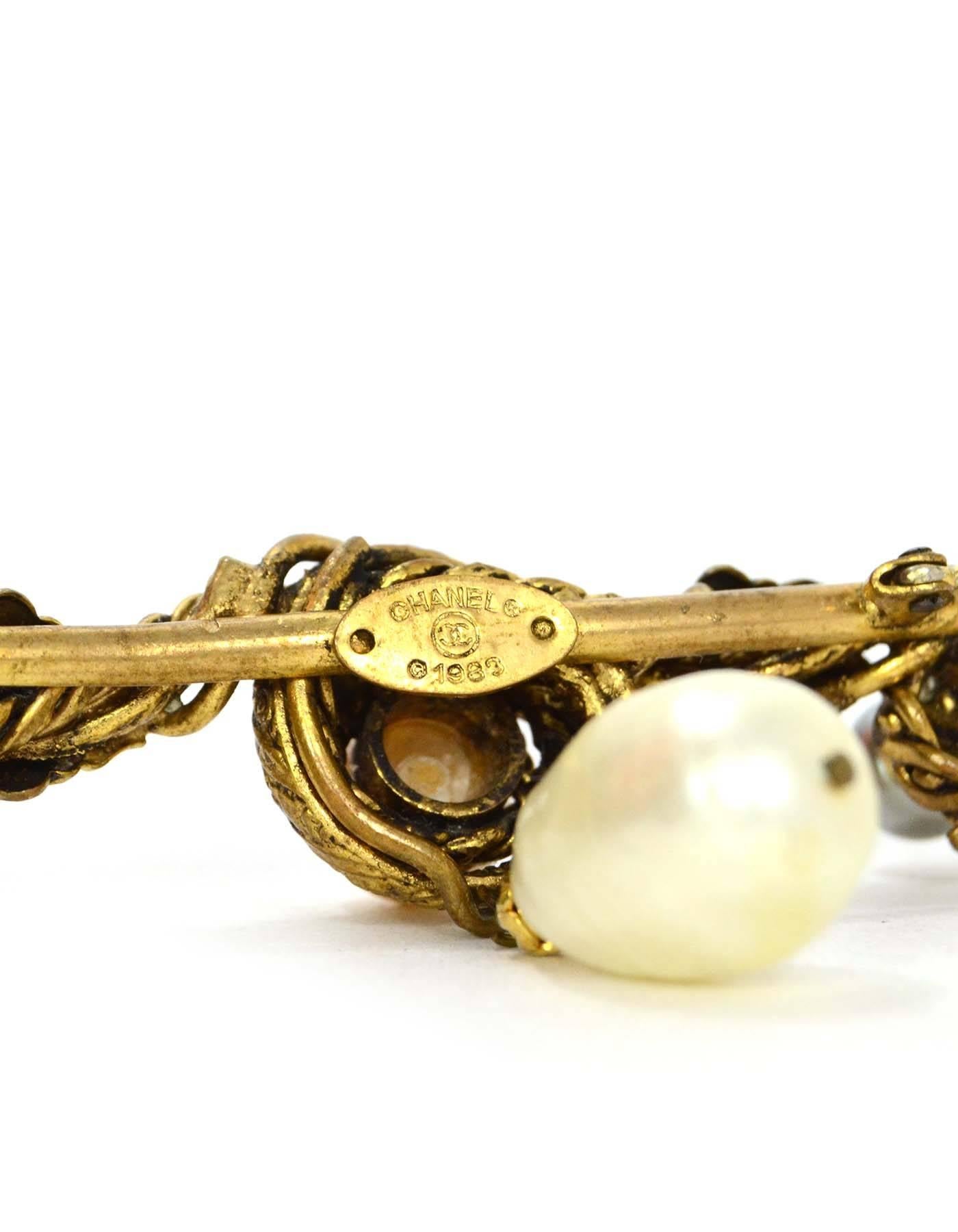 Chanel Vintage '83 Gold Leaf & Pearl Brooch
Features one tear drop faux pearl

Made In: France
Year of Production: 1983
Color: Goldtone, ivory and grey
Materials: Metal and faux pearl
Closure: Pin back closure
Stamp: Chanel CC 1983
Overall