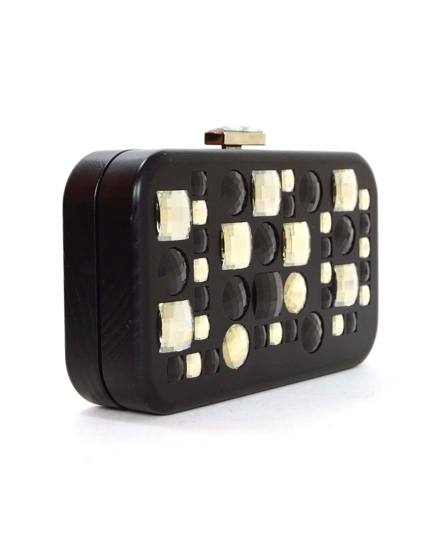 Devi Kroell Black Jeweled Hard Case Clutch 
Features large square and circular jewels on front of clutch
Made In: Italy
Color: Black
Hardware: Silvertone
Materials: Wood and jewels
Lining: Taupe satin
Closure/Opening: Hinge opening with push