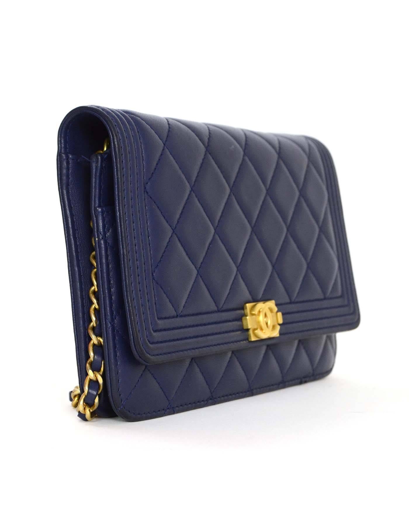 Chanel Navy Lambskin Boy WOC Bag 
Made In: Italy
Year of Production: 2015
Color: Navy
Hardware: Goldtone
Materials: Lambskin
Lining: Navy leather and grosgrain
Closure/Opening: Flap top with snap closure
Exteror Pockets: None
Interior