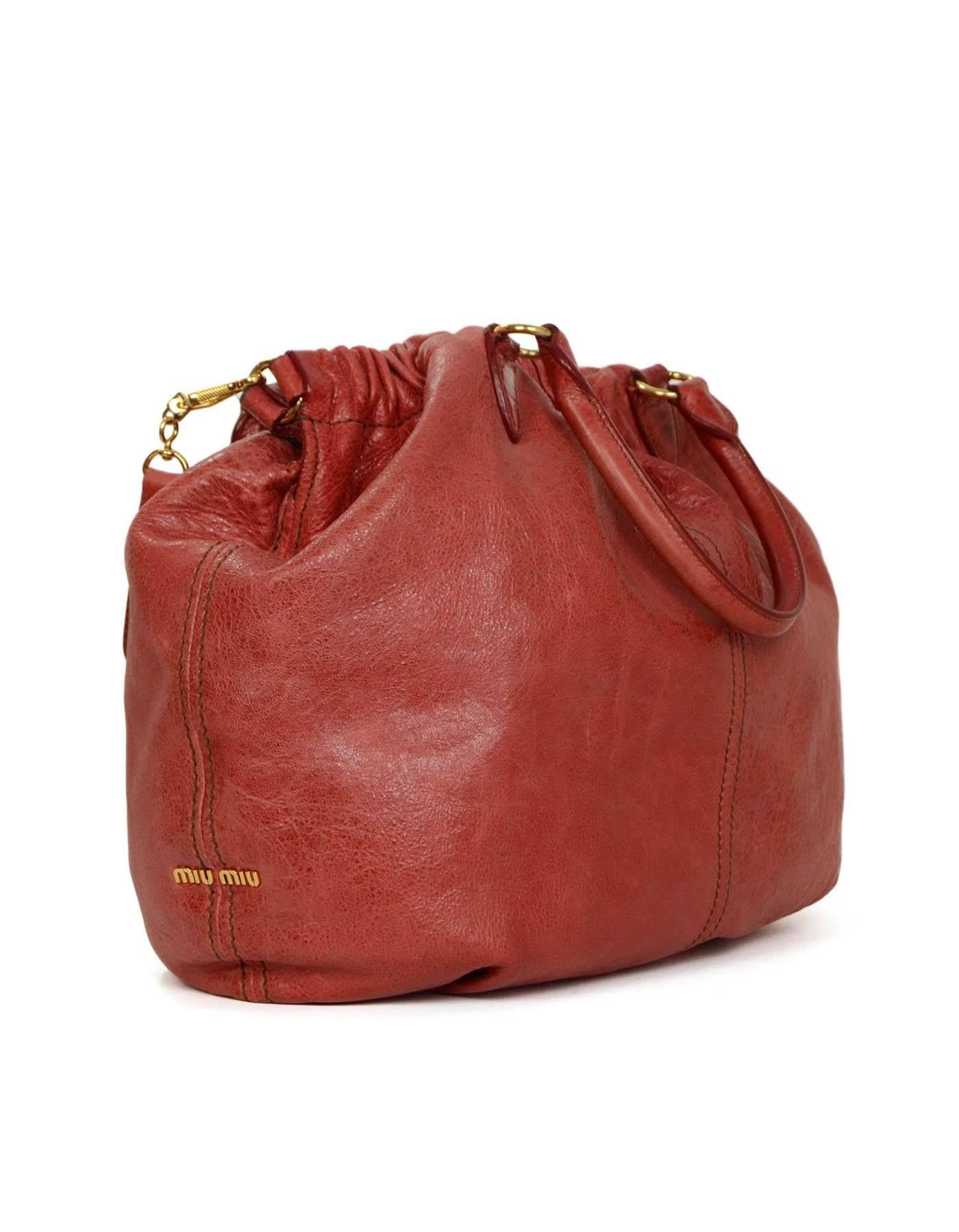 Miu Miu Red Distressed Leather Hobo Bag  
Features optional crossbody strap
Made In: Italy
Color: Red
Hardware: Goldtone
Materials: Distressed leather
Lining: Brown canvas
Closure/Opening: Open top with center magnetic snap closure
Exterior