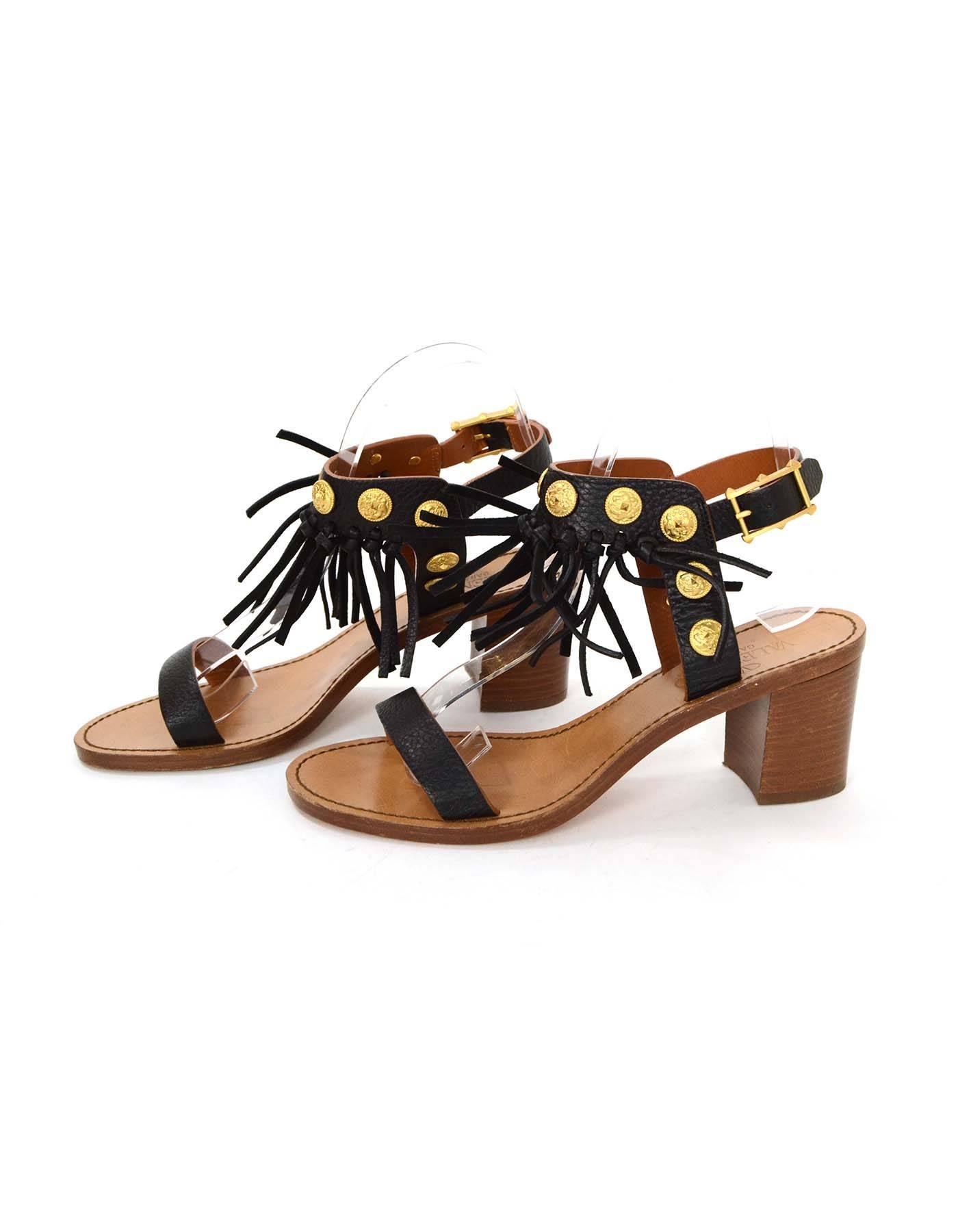 Valentino Black Leather Fringe Sandals 
Features gold coin studs throughout leather straps
Made In: Italy
Color: Black and tan
Materials: Leather, metal and wood
Closure/Opening: Ankle strap with buckle and notch closure
Sole Stamp: Valentino
