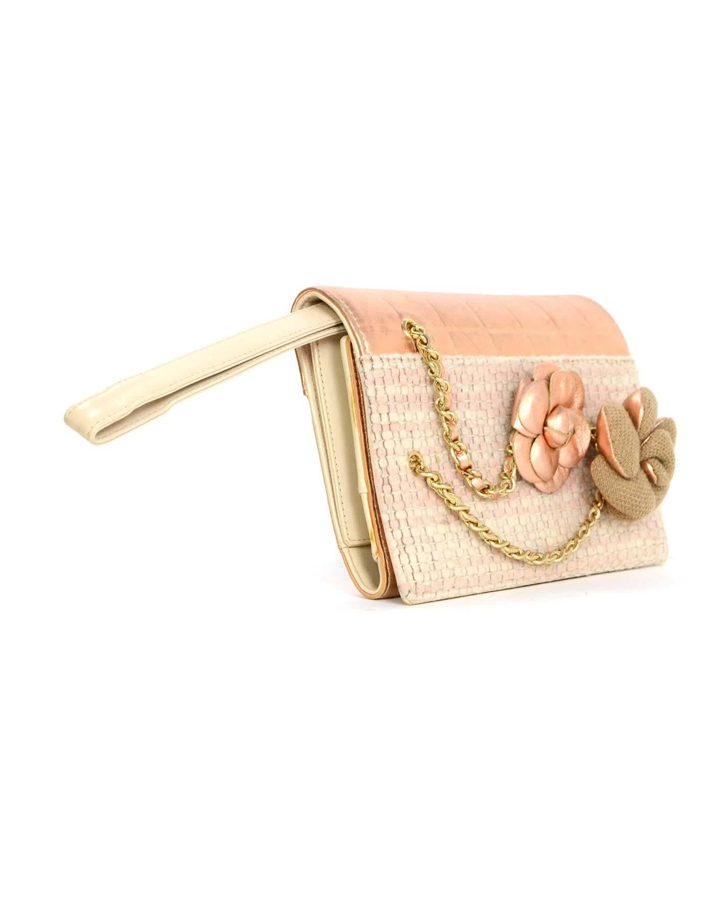Chanel Metallic Peach Tweed Wristlet Clutch GHW
Features camellia pins with metallic leather trim and gold-tone hardware.  Leather wristlet can be tucked in to be worn as a clutch

Made In: Italy
Year of Production: 2001
Color: Metallic peach