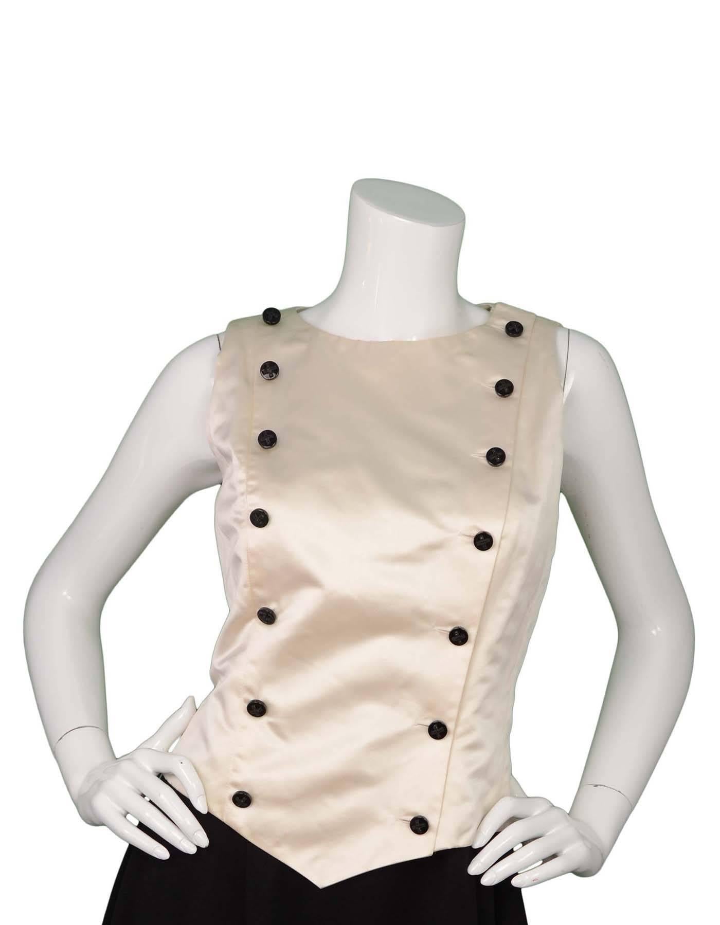 Chanel Ivory Satin Double Breasted Vest 
Features black buttons going down front sides with black x rhinestones

Made in: France
Year of Production: 2006
Color: White and black
Composition: 100% silk
Lining: Ivory, 100% silk
Closure/Opening: Double