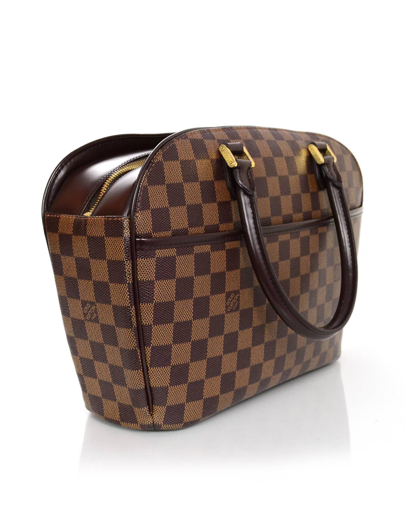 100% Authentic Louis Vuitton Damier Saria Horizontal Bag. Features all-over brown Damier print and one exterior pocket. Zip top with gold hardware, leather handles and trim. Orange textile lining with two interior pockets. Excellent pre-owned