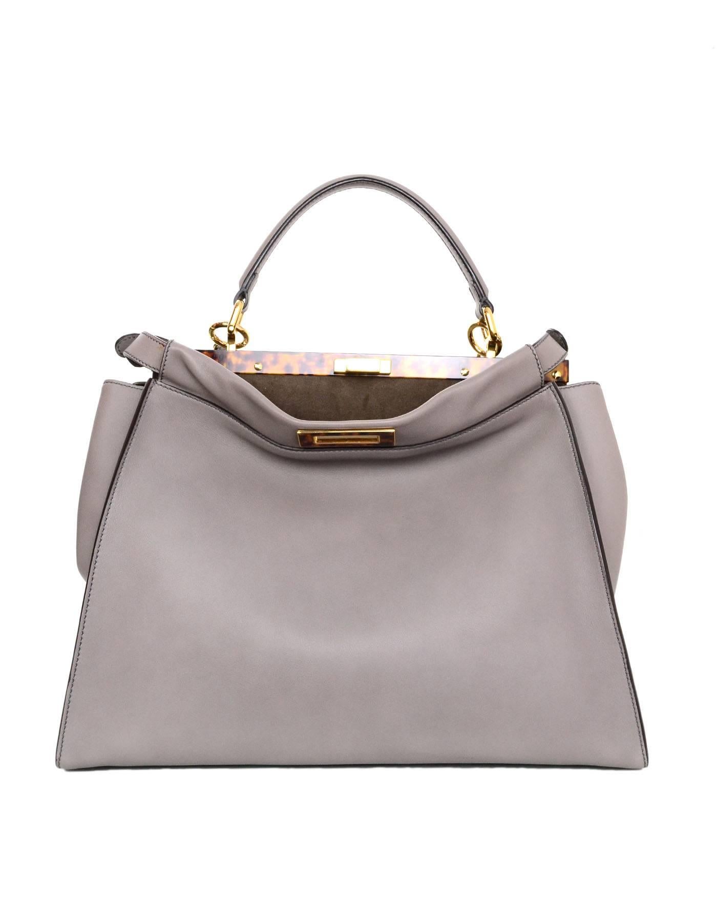 Fendi Grey Leather Large Peek-a-Boo Satchel
Features optional shoulder strap and peekaboo tortoise trim

Made In: Italy
Colors: Grey, brown tortoise
Hardware: Goldtone
Materials: Leather, metal, tortoise
Lining: Grey suede
Closure/Opening: Twist
