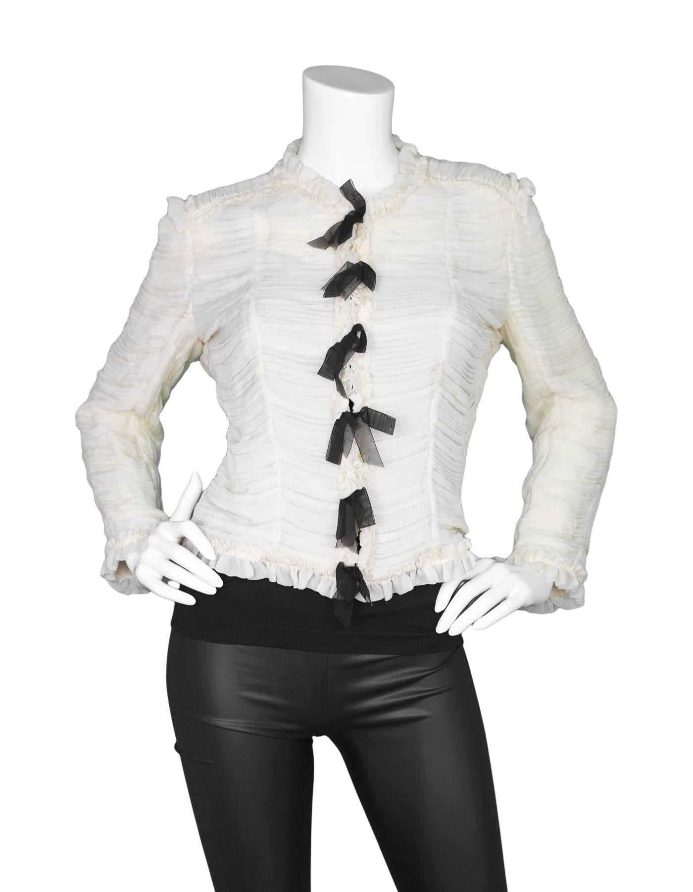 Chanel Cream & Black Silk Ruched Jacket
Features bows throughout opening

Made in: France
Year of Production: 2006
Color: Cream and black
Composition: 100% silk
Lining: None
Closure/opening: Front hook and eye closure
Exterior Pockets: