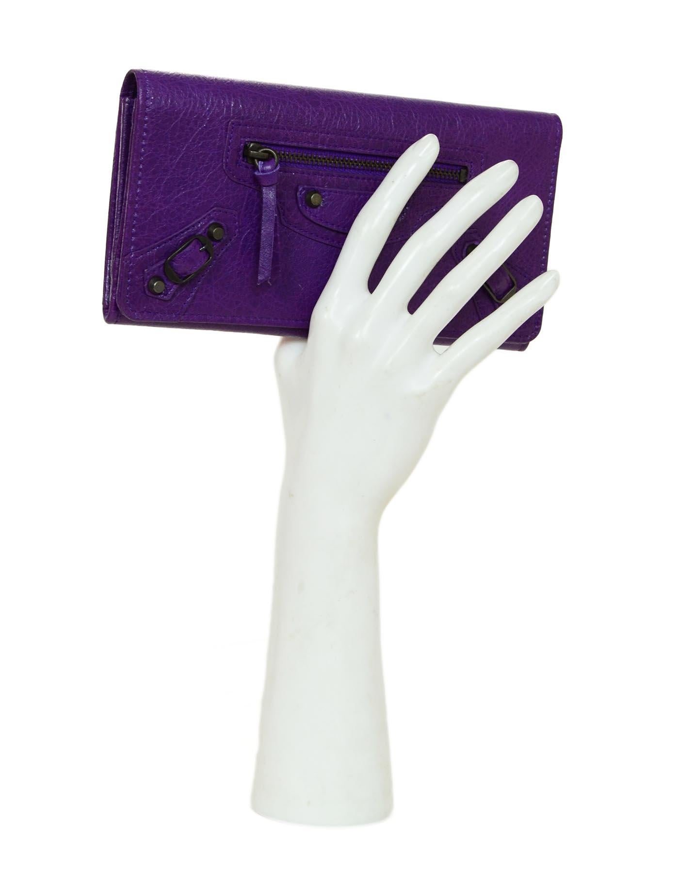 Balenciaga Purple Leather Classic Wallet W/ Brass Hardware & Dust Bag

Made In: Italy
Color: Purple
Hardware: Brass
Materials: Leather, metal
Lining: Purple leather and black textile
Closure/Opening: Flap top with snap
Exterior Pockets: Front front