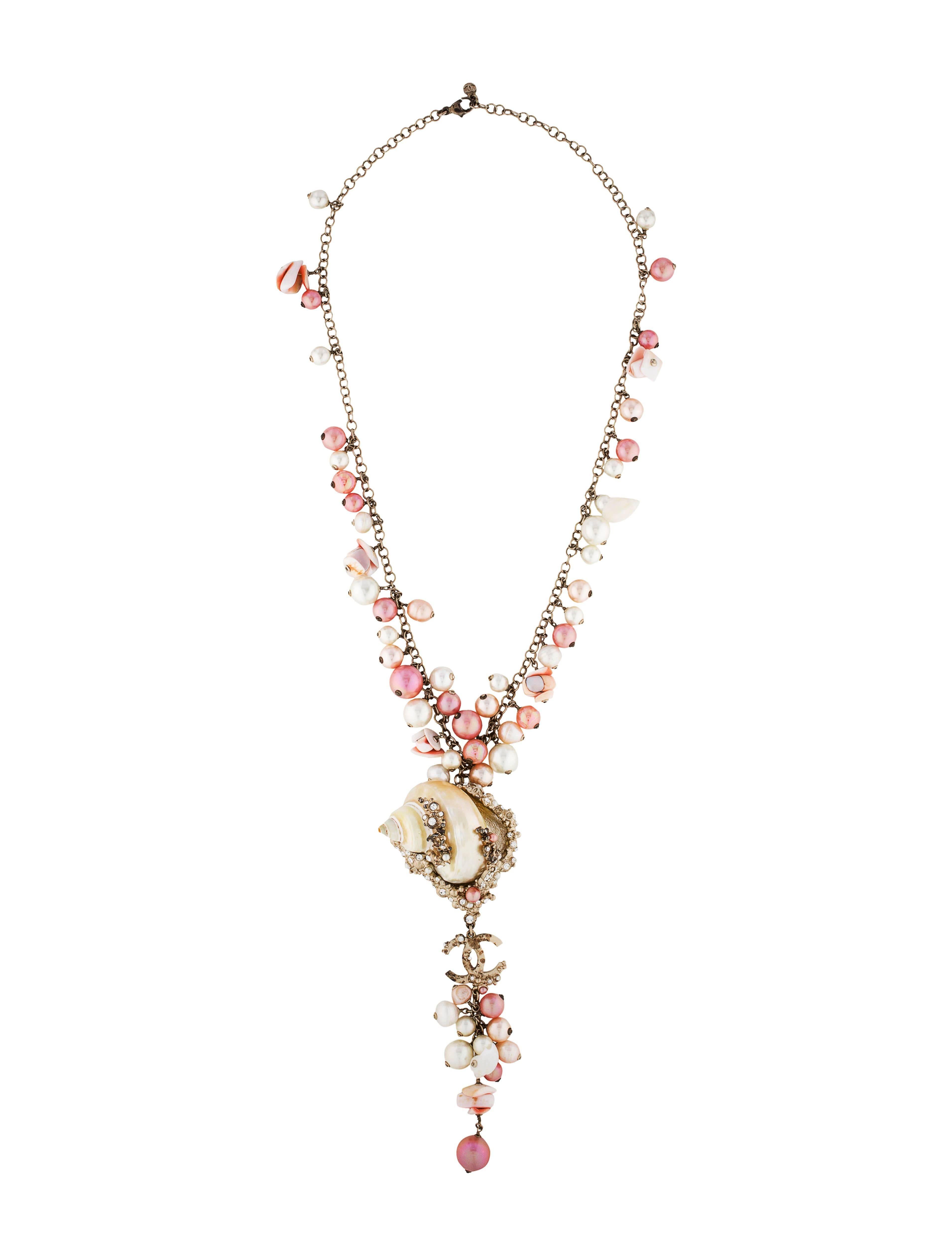 Chanel Pink & White MOP Shell Drop Necklace
​Features pink, peach and ivory faux pearls & shell chips
Made In: France
Year of Production: 2007
Color: Pink, ivory, peach and brass
Materials: MOP shells, beads, faux pearls, rhinestones and