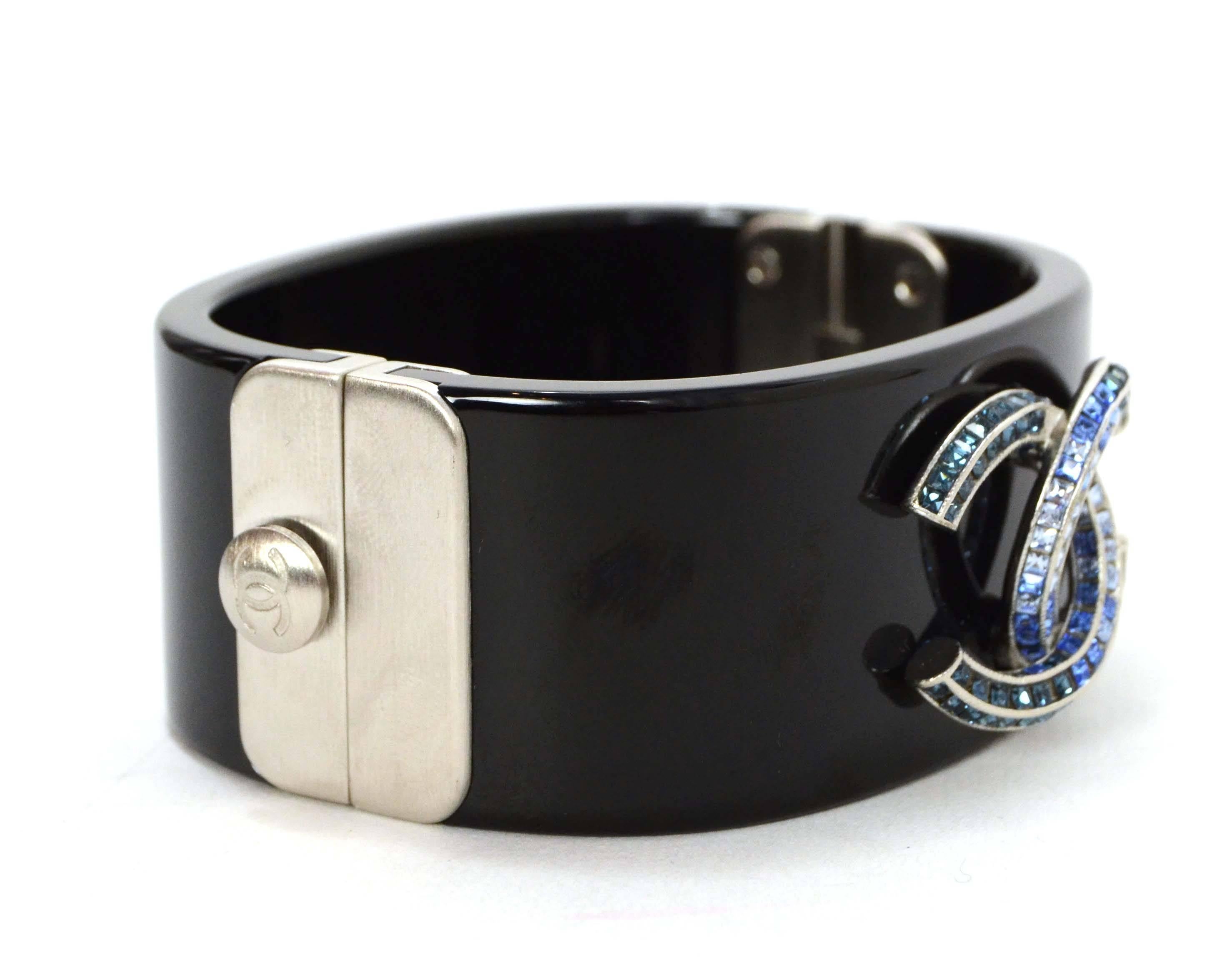 Chanel ‘15 Black Resin & Blue Crystal CC Cuff Bracelet
Features light and dark blue crystals in silvertone CC pendant
Made In: France
Year of Production: 2015
Color: Black, blue and silvertone
Materials: Resin, metal and crystals
Closure: