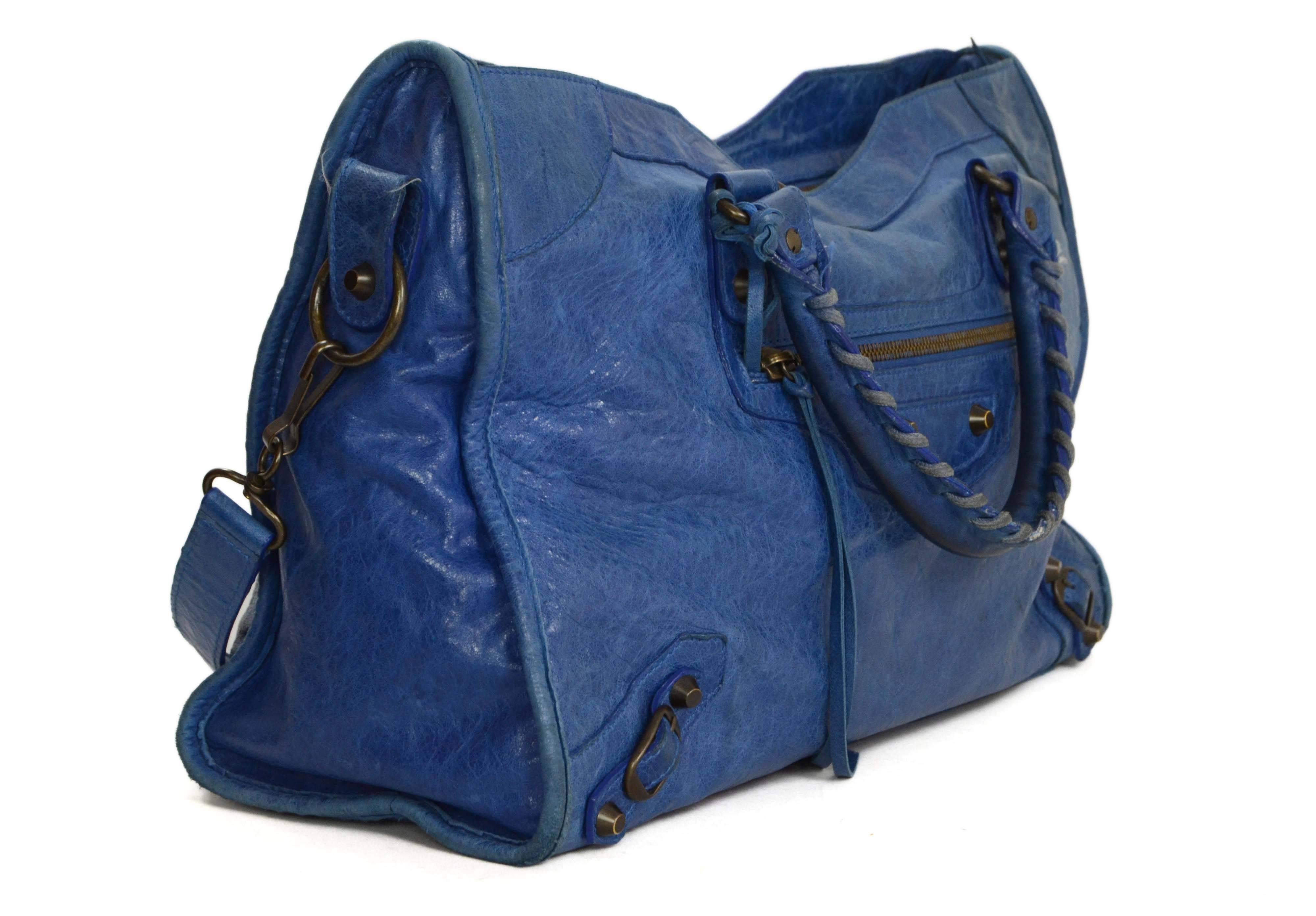 Balenciaga Blue Distressed Leather “City” Bag
Features detachable shoulder strap
Made In: Italy
Color: Blue
Hardware: Brass
Materials: Leather and metal
Lining: Black cotton-blend
Closure/Opening: Double zip across top
Exterior Pockets: One