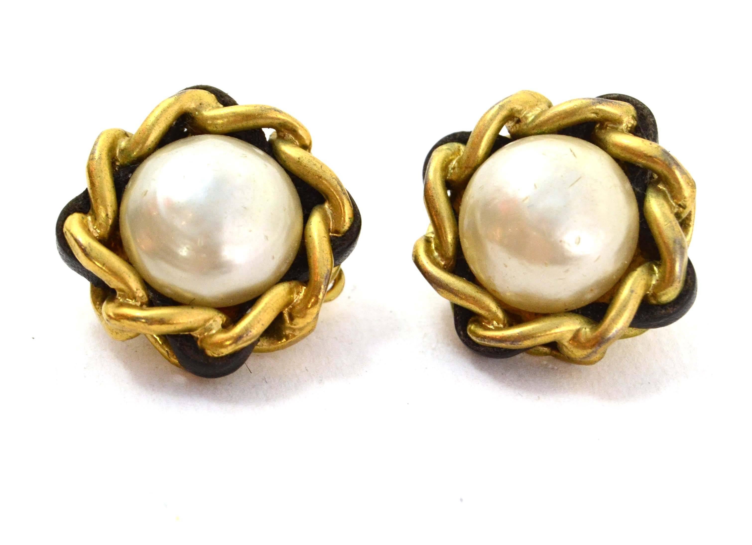 Chanel Vintage '93 Pearl Clip On Earrings 
Features leather woven chain link detail surrounding pearl
Made In: France
Year of Production: 1993
Color: Ivory, goldtone and black
Materials: Faux pearl, metal, and leather
Closure: Clip on
Stamp: 93 CC