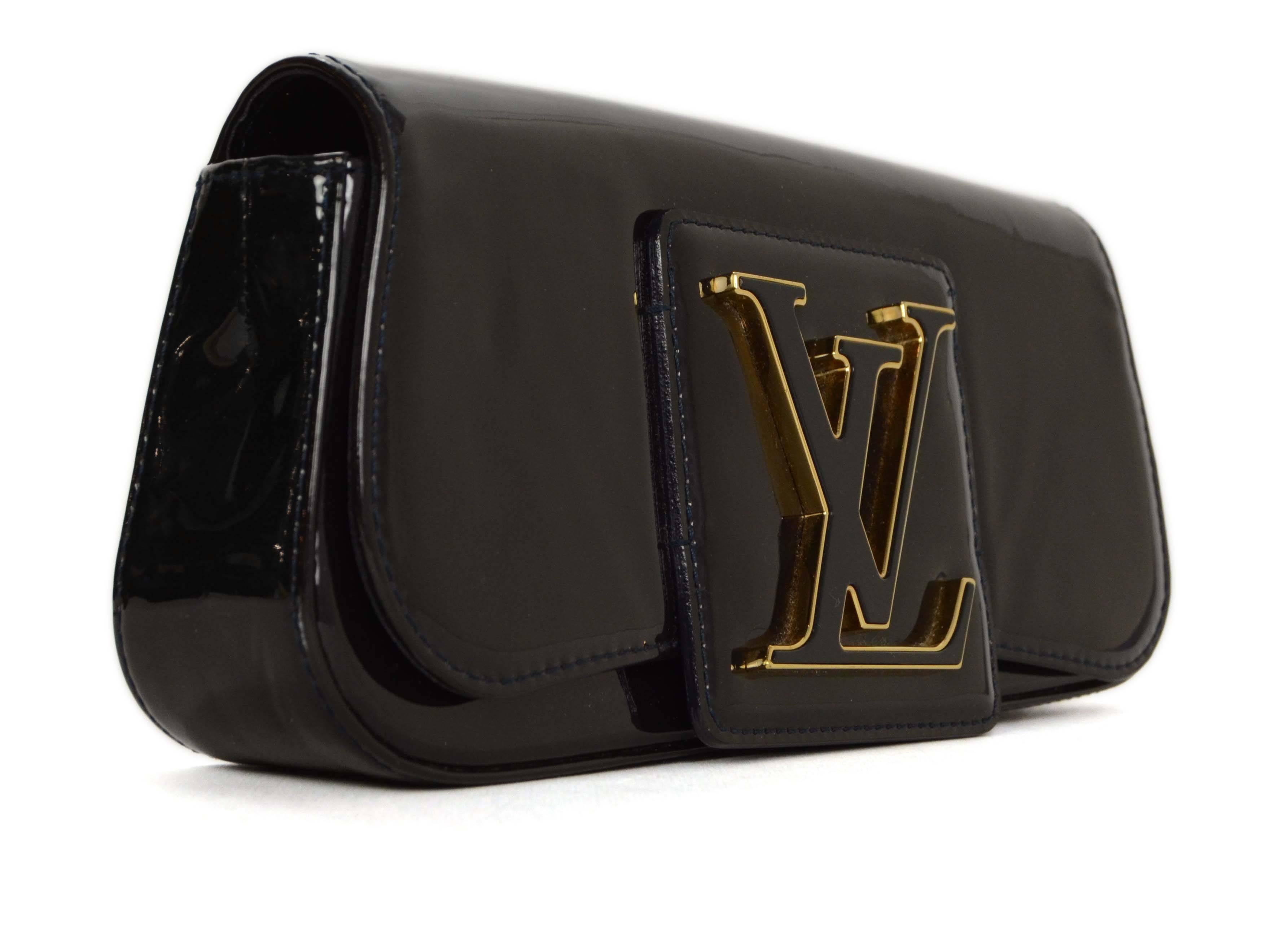 Louis Vuitton Black Patent Sobe Clutch 
Features goldtone and black enamel LV on flap top
Made In: Spain
Year of Production: 2010
Color: Black and goldtone
Materials: Patent leather, enamel and metal
Lining: Black canvas
Closure/Opening: Flap